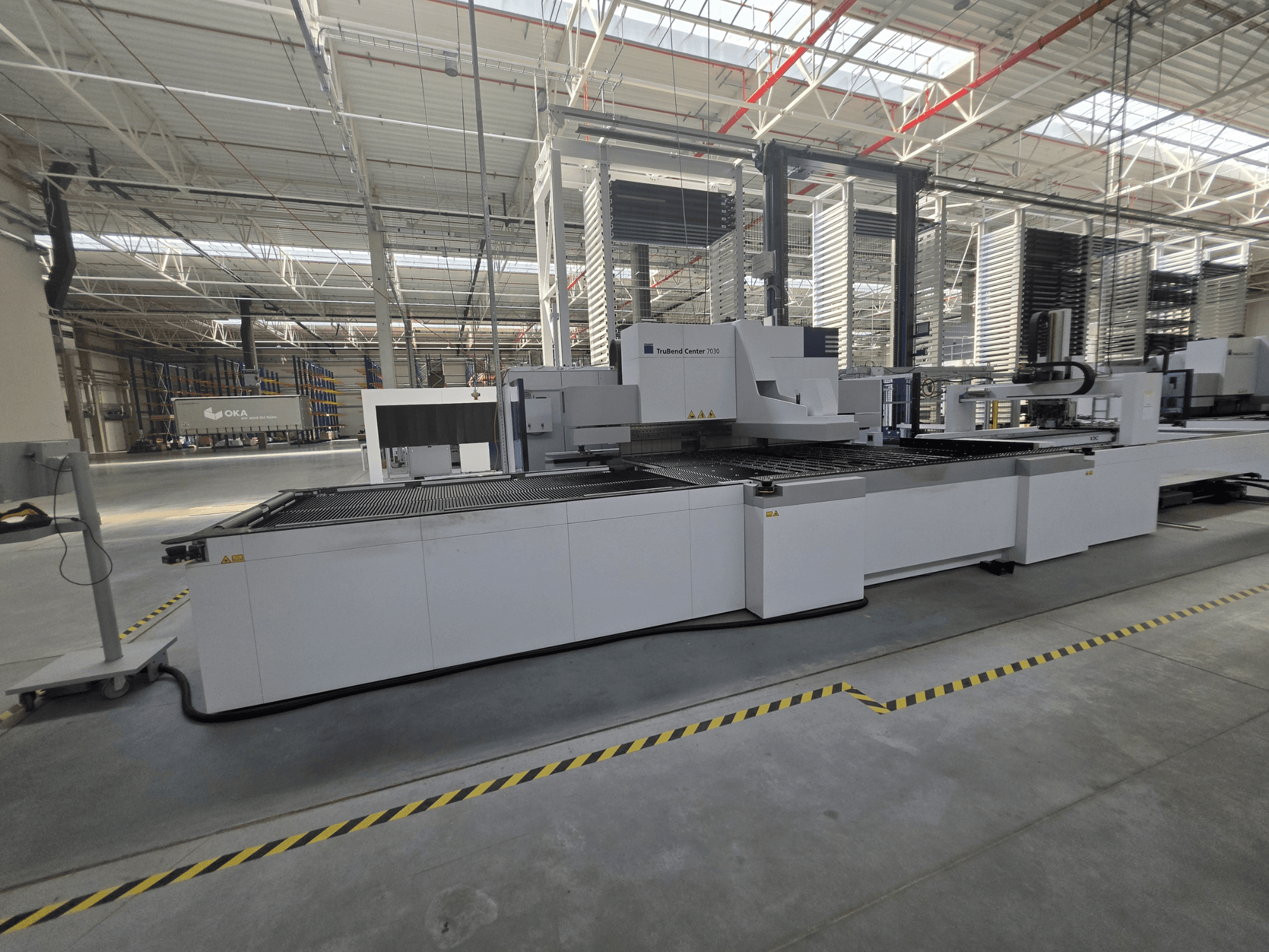 Гнучкий прес TRUMPF TruBend Center 7030, вид збоку, на якому видно робочу зону та органи управління у просторому цеху.