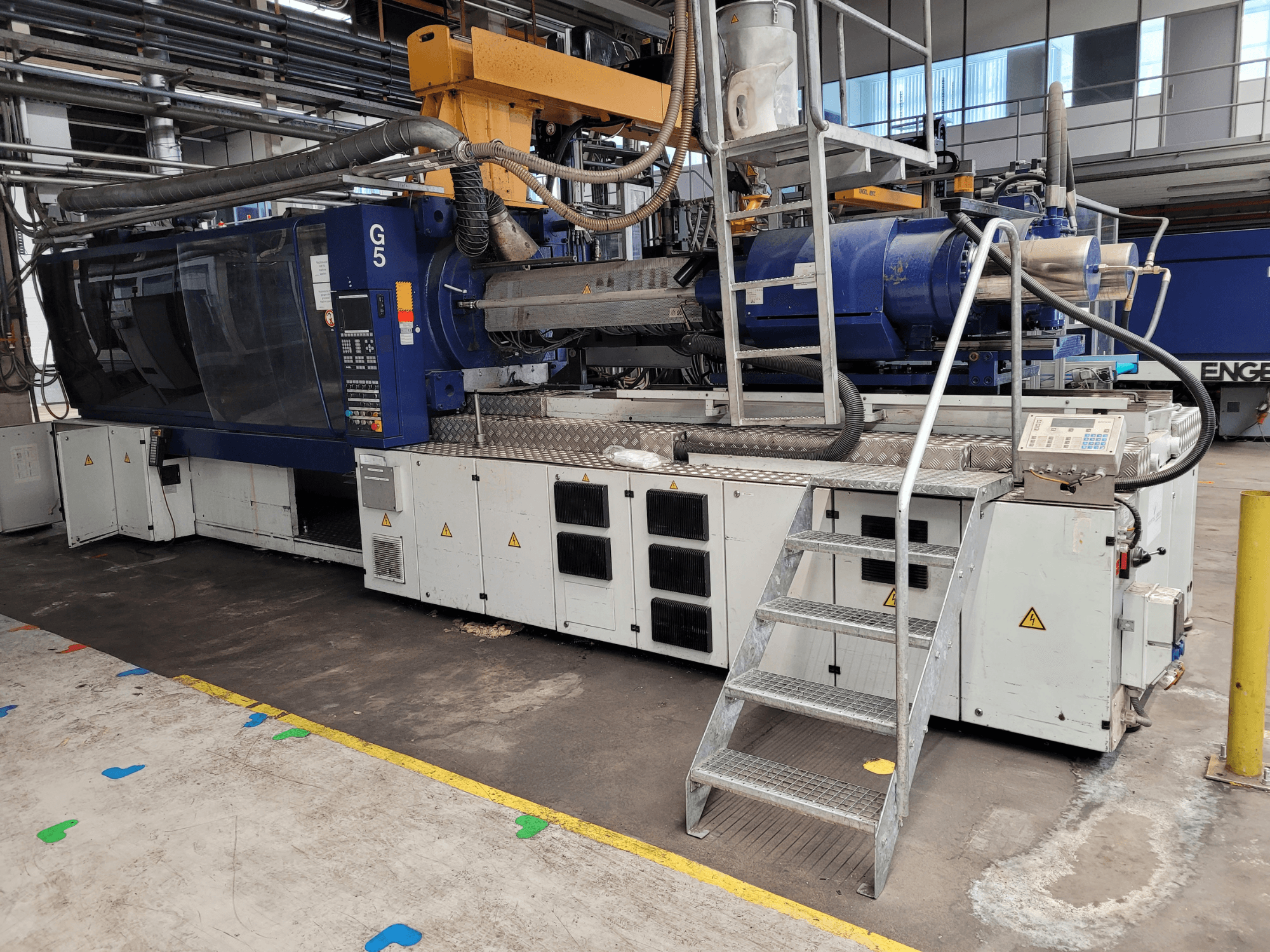 Термопластавтомат G5, вид збоку, видно панель керування, драбину та робочу поверхню з нержавіючої сталі.