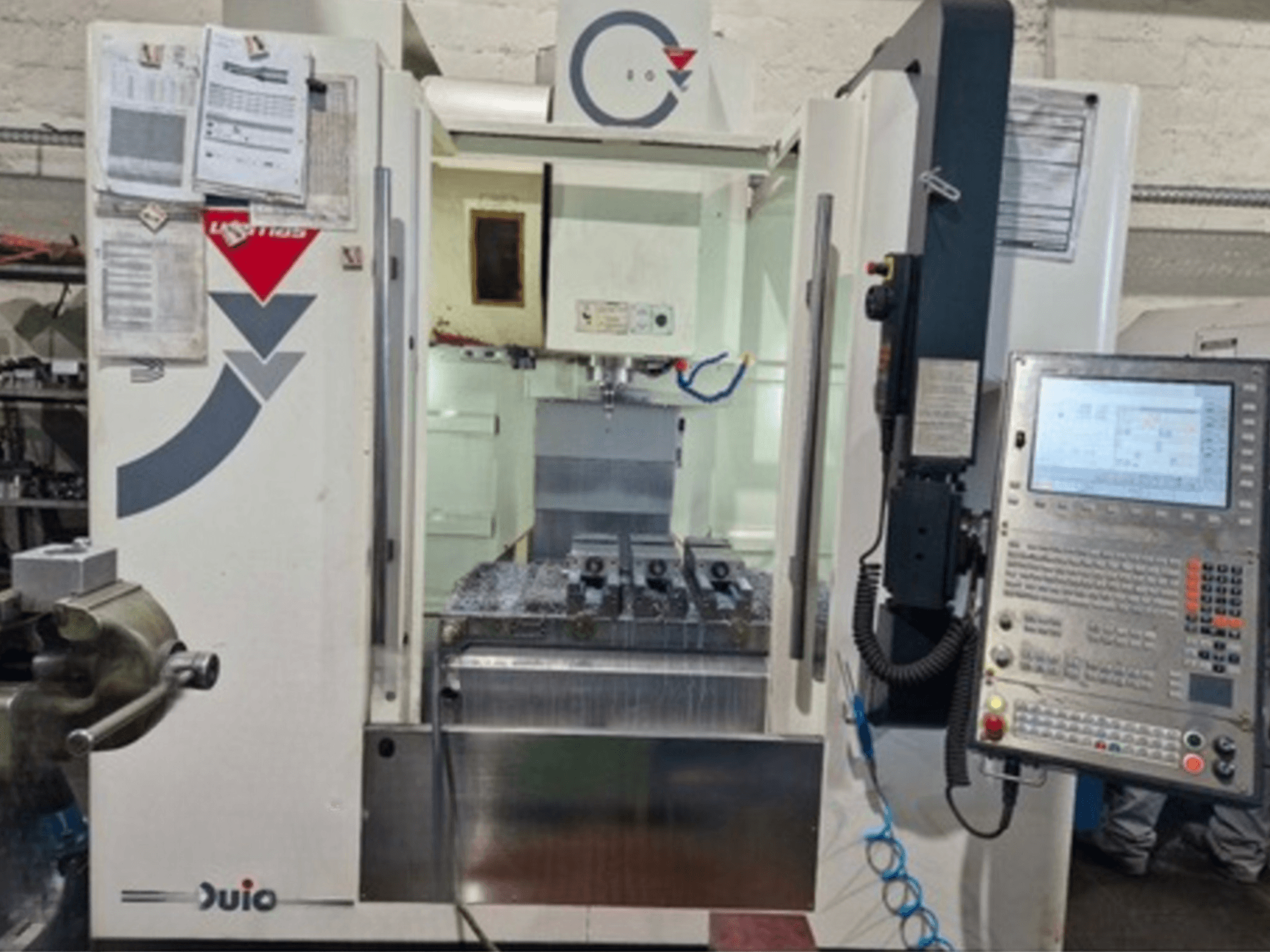 Вид спереду вертикального обробного центру WEMAS VZ 860 з панеллю керування та інтерфейсом ЧПК, з прикріпленими документами.