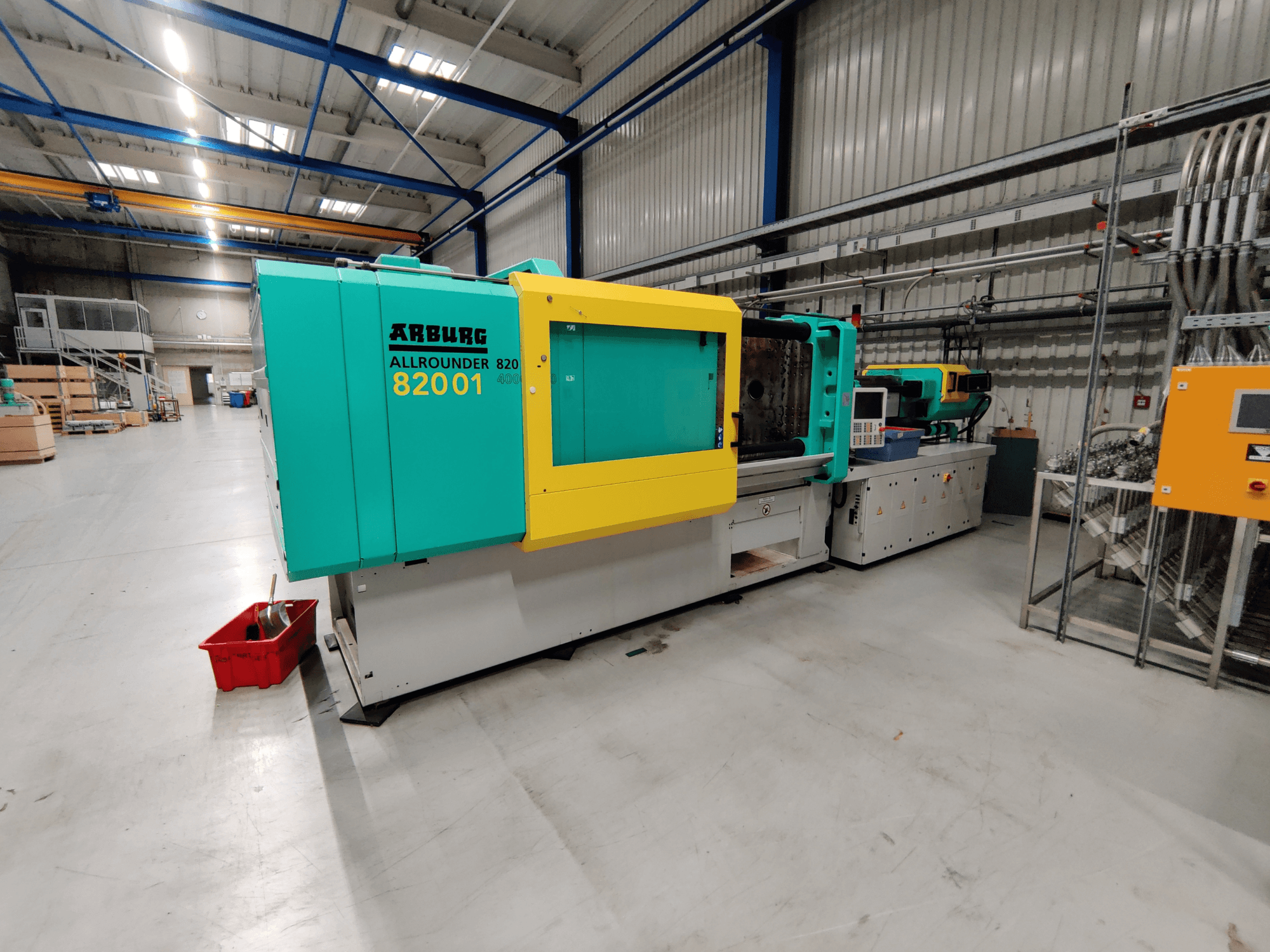 Вид спереду гідравлічної машини для лиття під тиском Arburg 820 S 4000-2100 з яскраво-зеленими та жовтими панелями.