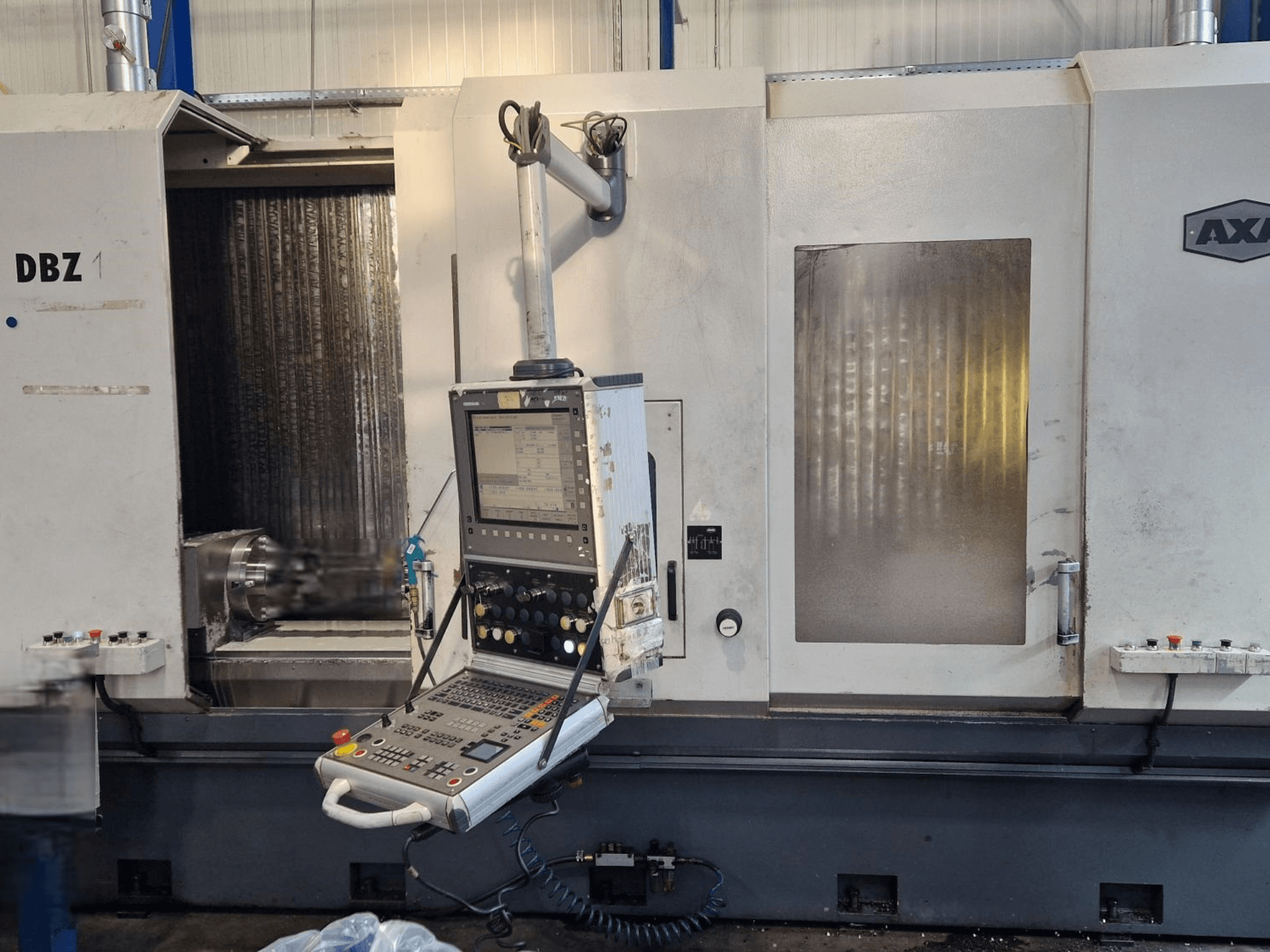 Вертикальний обробний центр AXA DBZ показаний під кутом спереду, з панеллю керування та видимою зоною ріжучого інструменту.