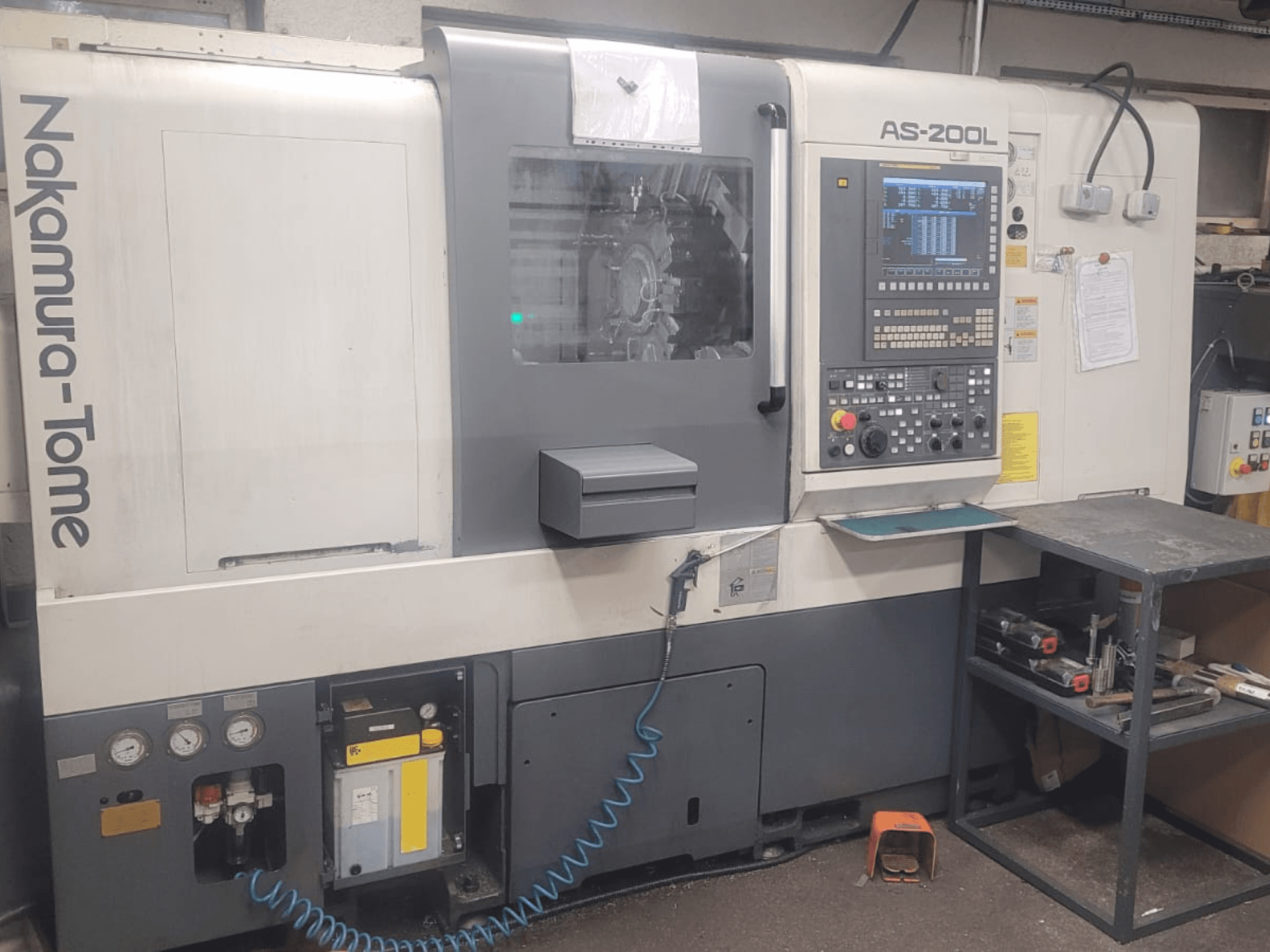 Горизонтальний токарний верстат NAKAMURA-TOME AS-200L, вид спереду з панеллю керування, шпинделем та функціями верстата.