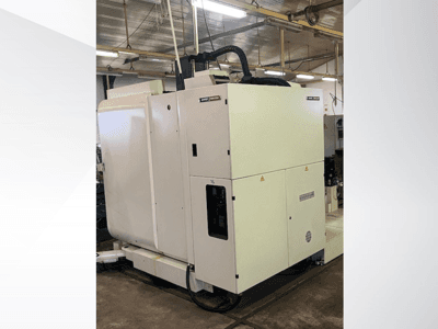 Білий промисловий верстат з ЧПУ, вид спереду, з панеллю керування та вентиляцією, в умовах майстерні.