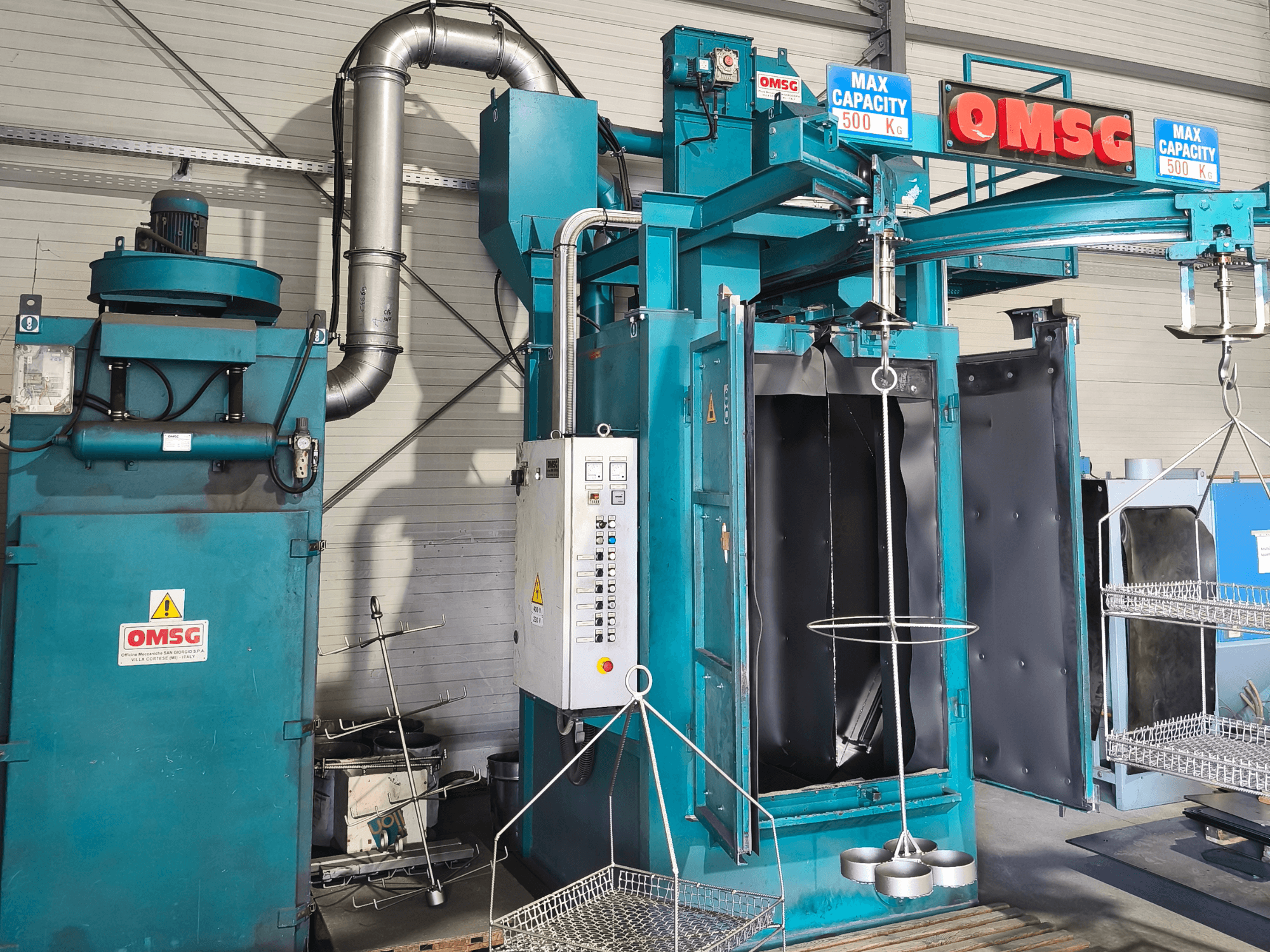 Промислова очисна машина OMSG з максимальною вантажопідйомністю 500 кг, демонстраційною панеллю керування та відкритою камерою для очищення деталей.