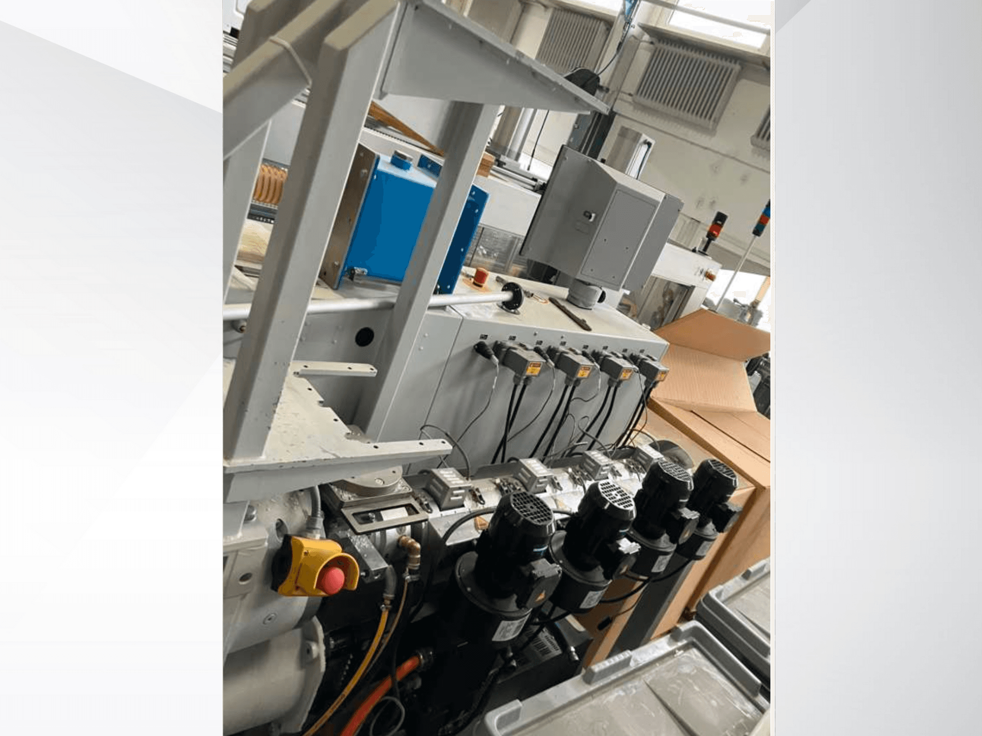 Панель керування промисловим обладнанням з декількома двигунами, датчиками та монітором; вигляд збоку всередині заводської установки.