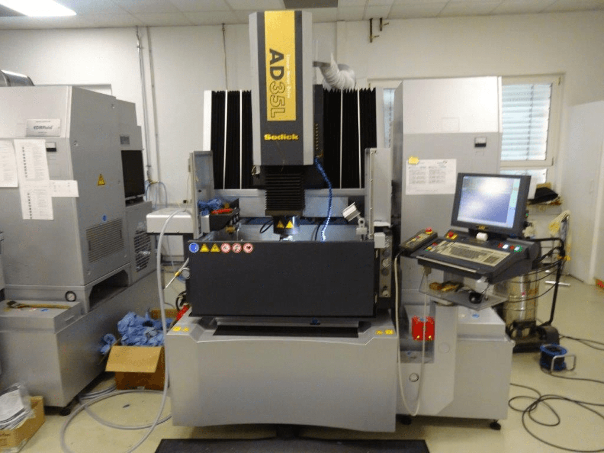 Електроерозійна машина Sodick AD35L, вид спереду з панеллю керування, системою охолодження та робочою зоною.