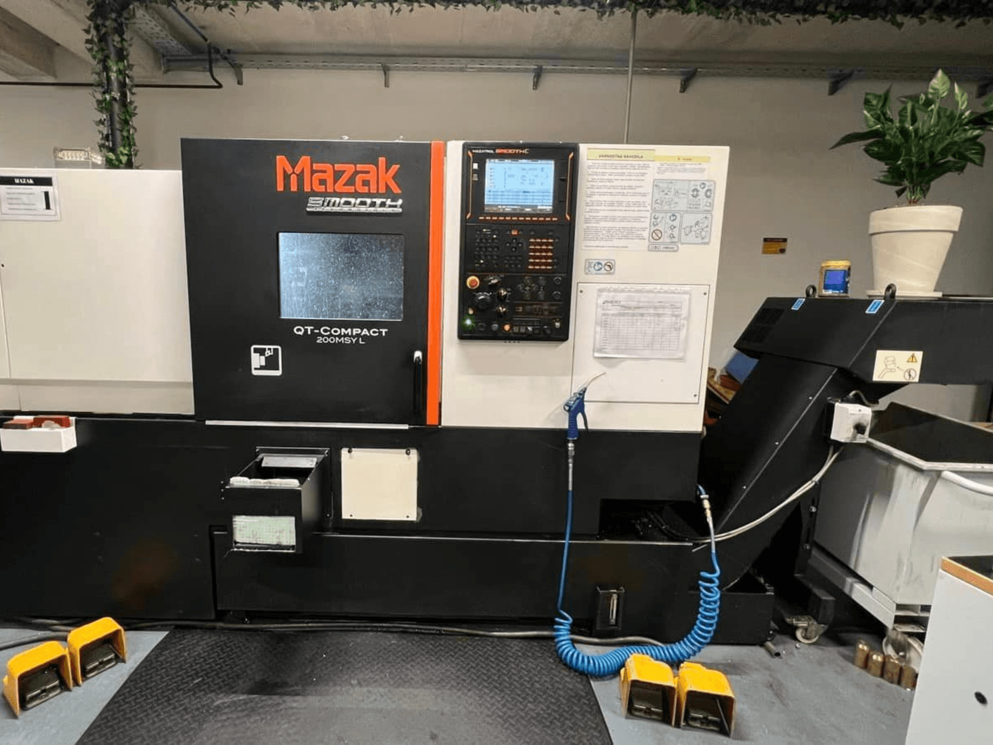 Горизонтальний токарний верстат Mazak QUICK TURN COMPACT 200 MSY L, вид спереду, з панеллю керування та відсіком для зберігання інструментів.