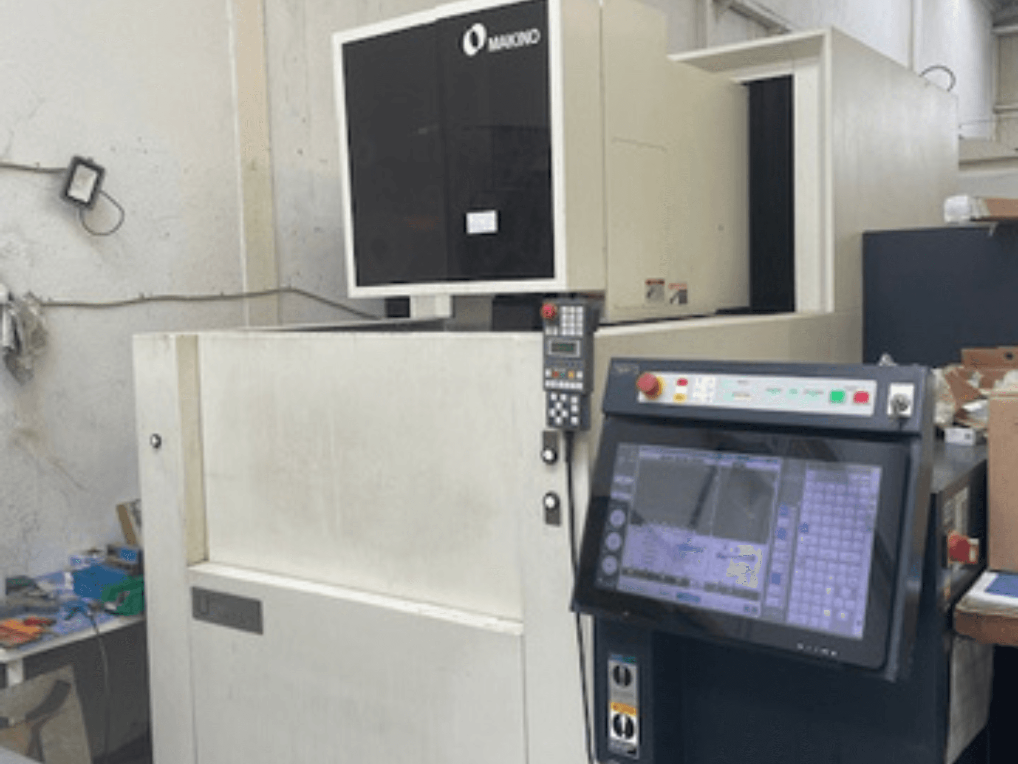 Електроерозійний дротовий верстат Makino U6 HEAT в майстерні, вид спереду з панеллю керування та цифровим дисплеєм.