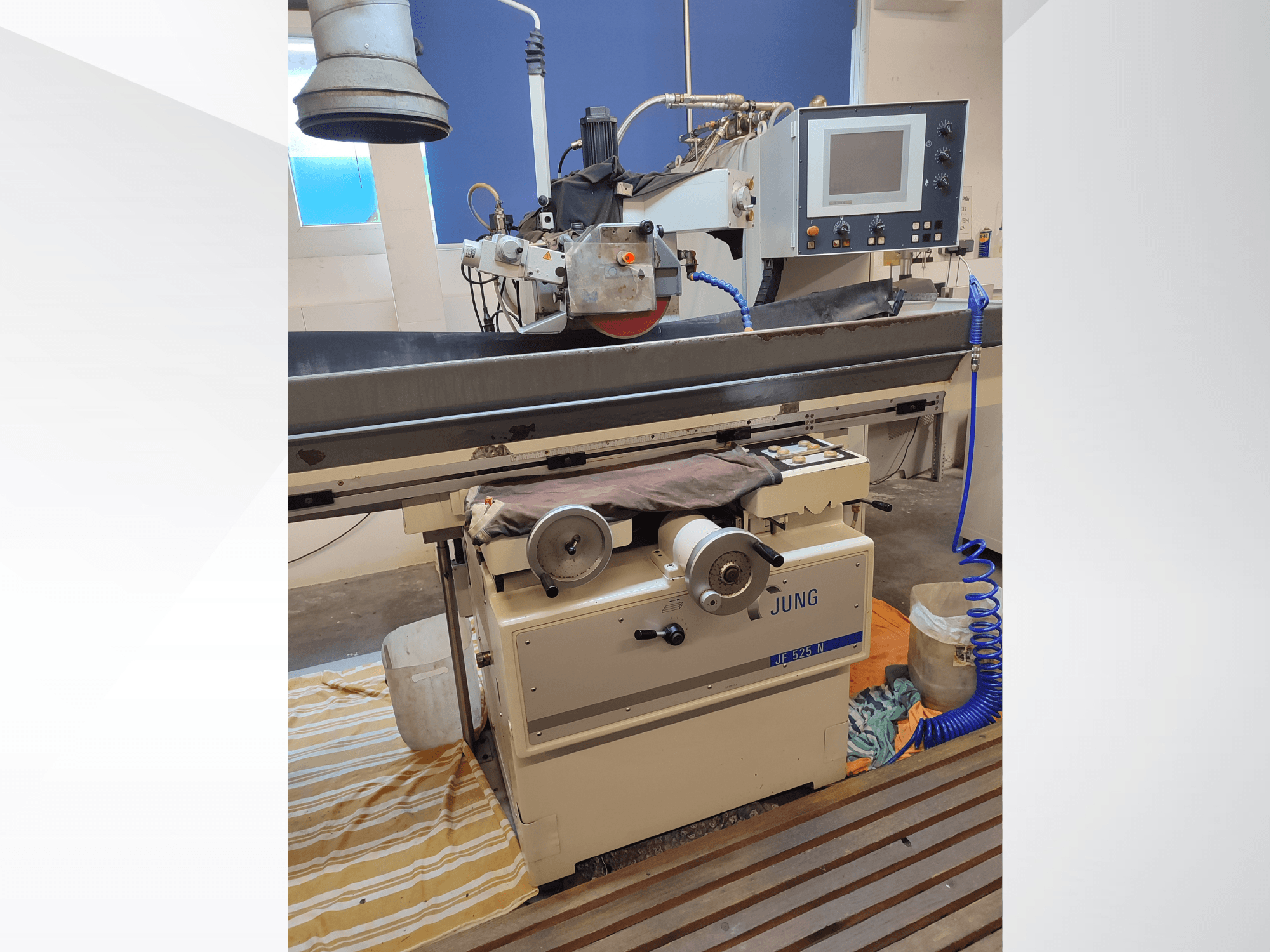 Плоскошліфувальна машина JUNG JF 525 N, вид спереду: шліфувальний круг, панель керування та деталі основи.