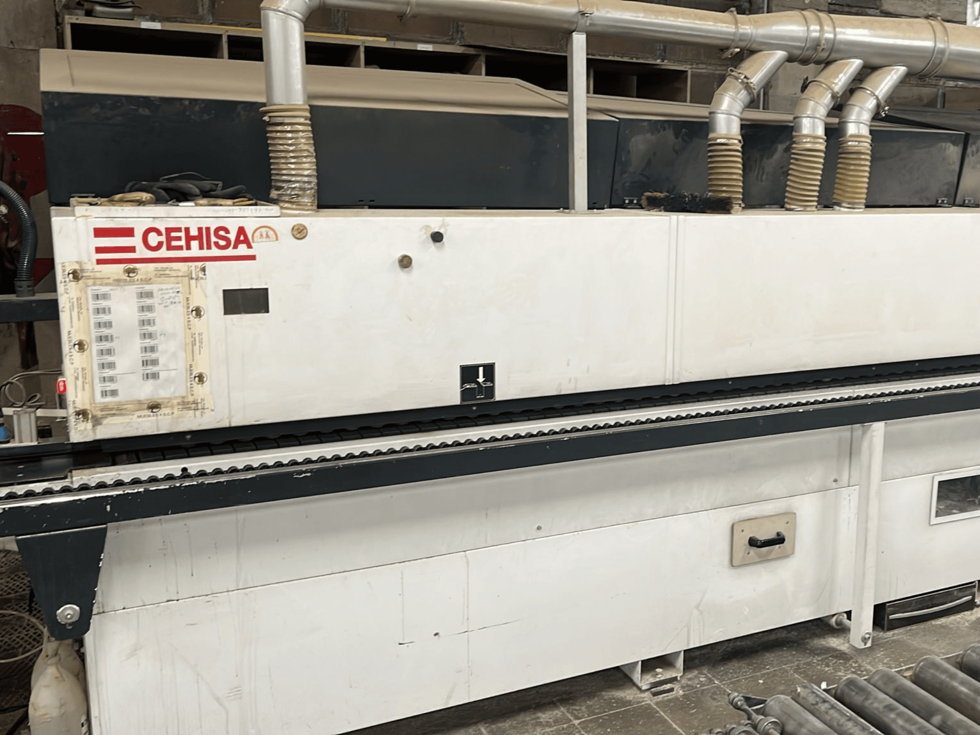 Обкантовувальна машина CEHISA PRO 12 CONCEPT у вигляді спереду, на якій видно панель управління, труби для відведення пилу та конвеєрну стрічку.