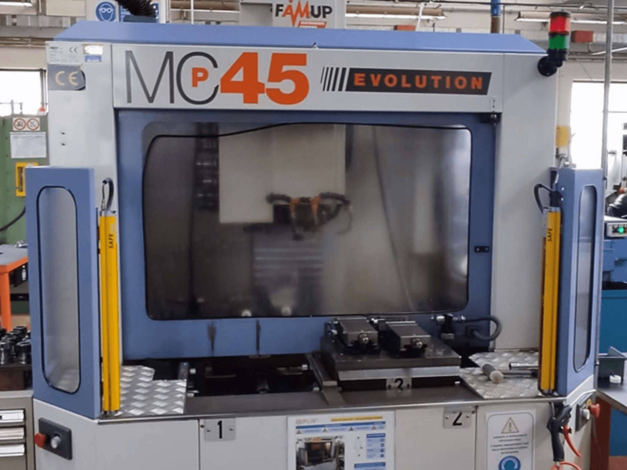 Вертикальний обробний центр FAMUP MCP 45 E, вид спереду, демонструє елементи керування та робочу зону фрезерування.