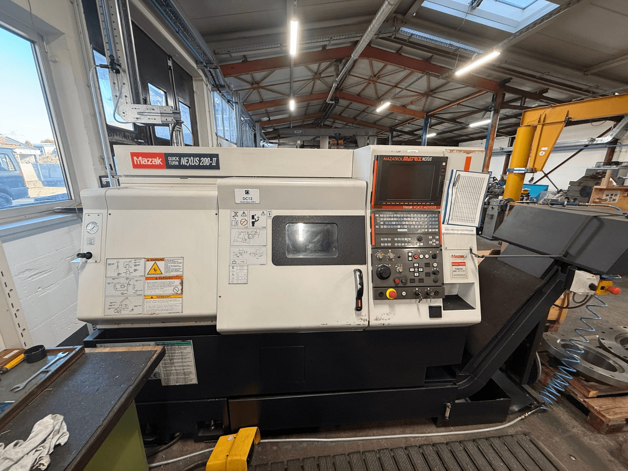 Горизонтальний токарний верстат Mazak QUICK TURN NEXUS 200-II, вид спереду, на якому видно панель управління та робочі елементи.