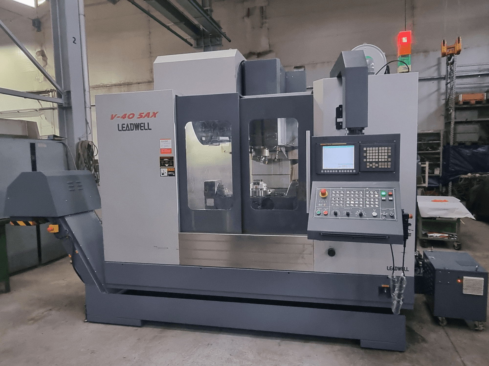 Вертикальний обробний центр Leadwell V40 5AX, вид спереду, на якому видно панель управління та зону обробки з сигнальними вогнями безпеки.