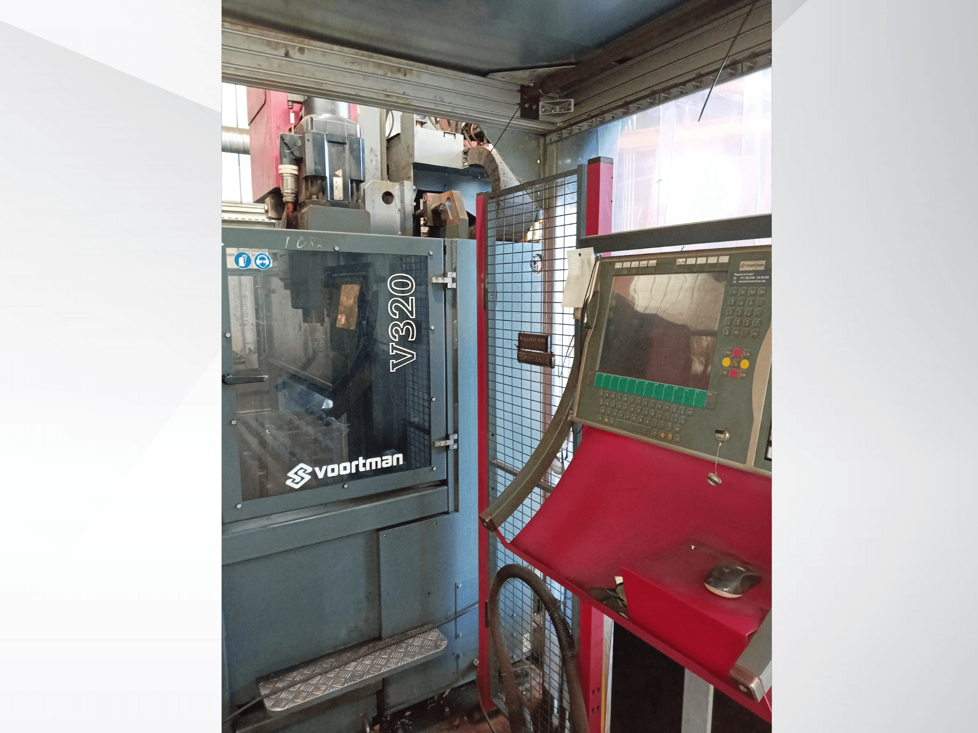 Вид спереду верстата з ЧПК Voortman V320 з панеллю керування з кнопками, екраном дисплея та захисною сітчастою огорожею.