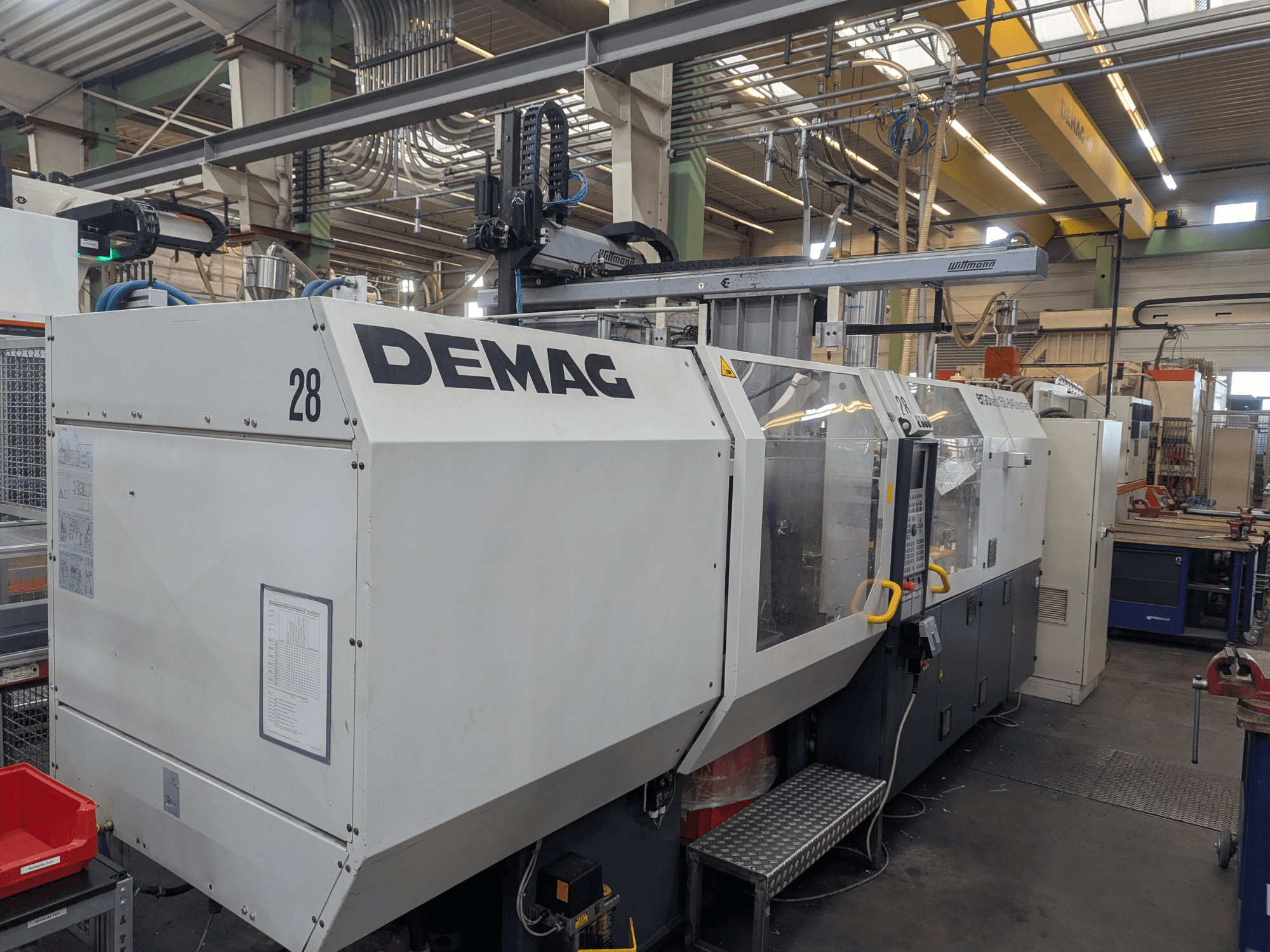 Вид спереду гідравлічної машини для лиття під тиском DEMAG ERGOTECH 1500-840, що демонструє елементи керування та елементи безпеки.