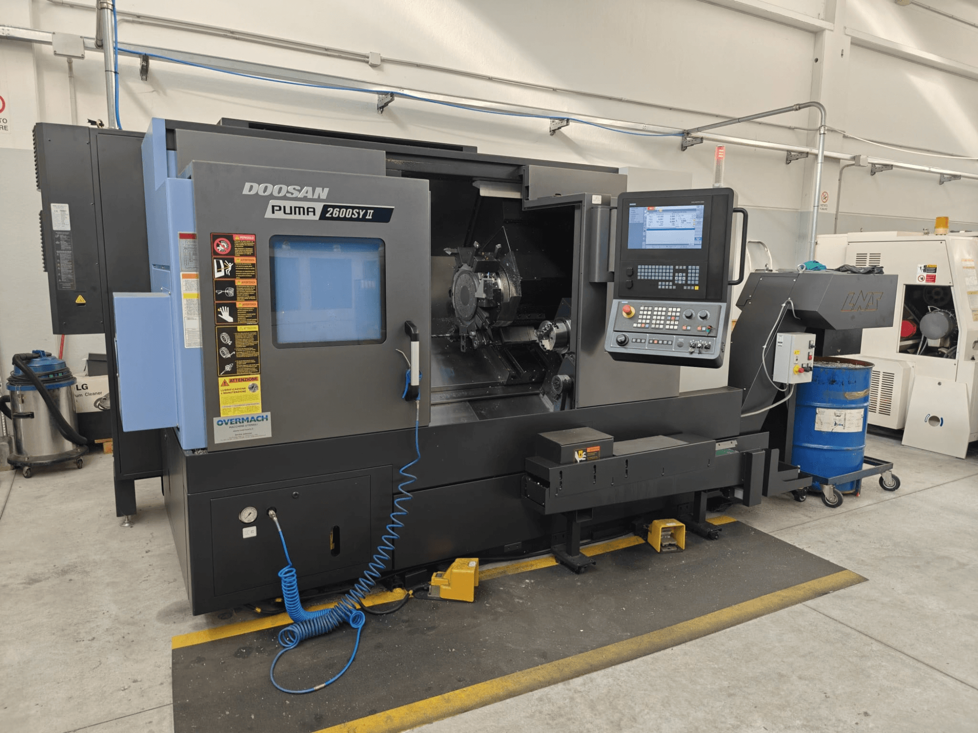 Горизонтальний токарний верстат DOOSAN Puma 2600 SY II, вид спереду, з панеллю керування та індикаторами робочого стану.