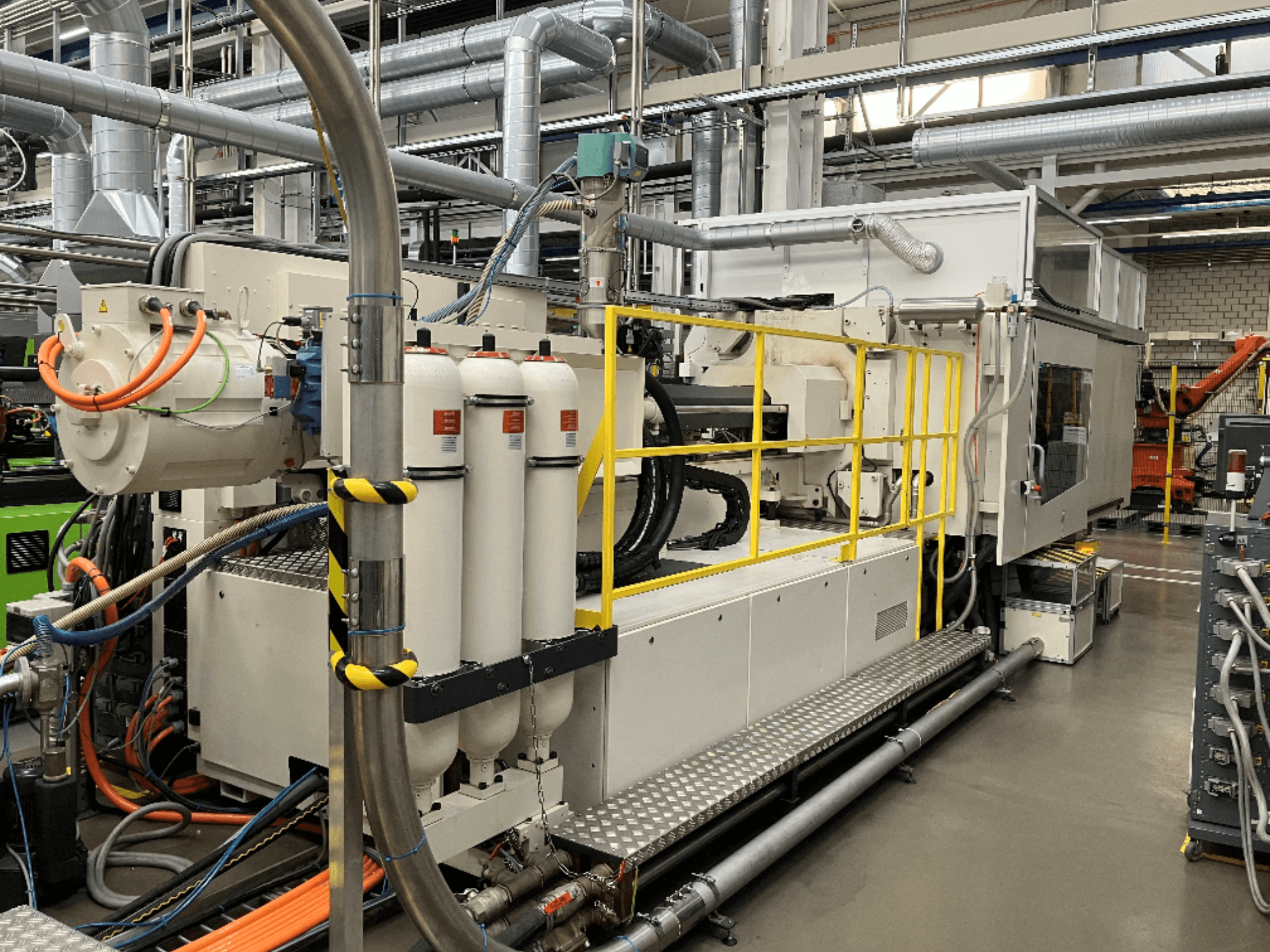 Промислова машина з біло-сірим корпусом, кількома шлангами та фільтрувальними баками; вигляд збоку, що демонструє робочу установку.