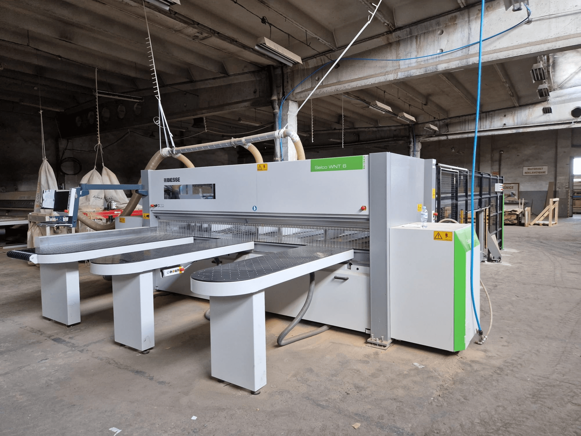 Панельна пила Biesse Selco WNT 6 у заводських умовах, вид спереду з підключеними полотнами та панеллю керування.