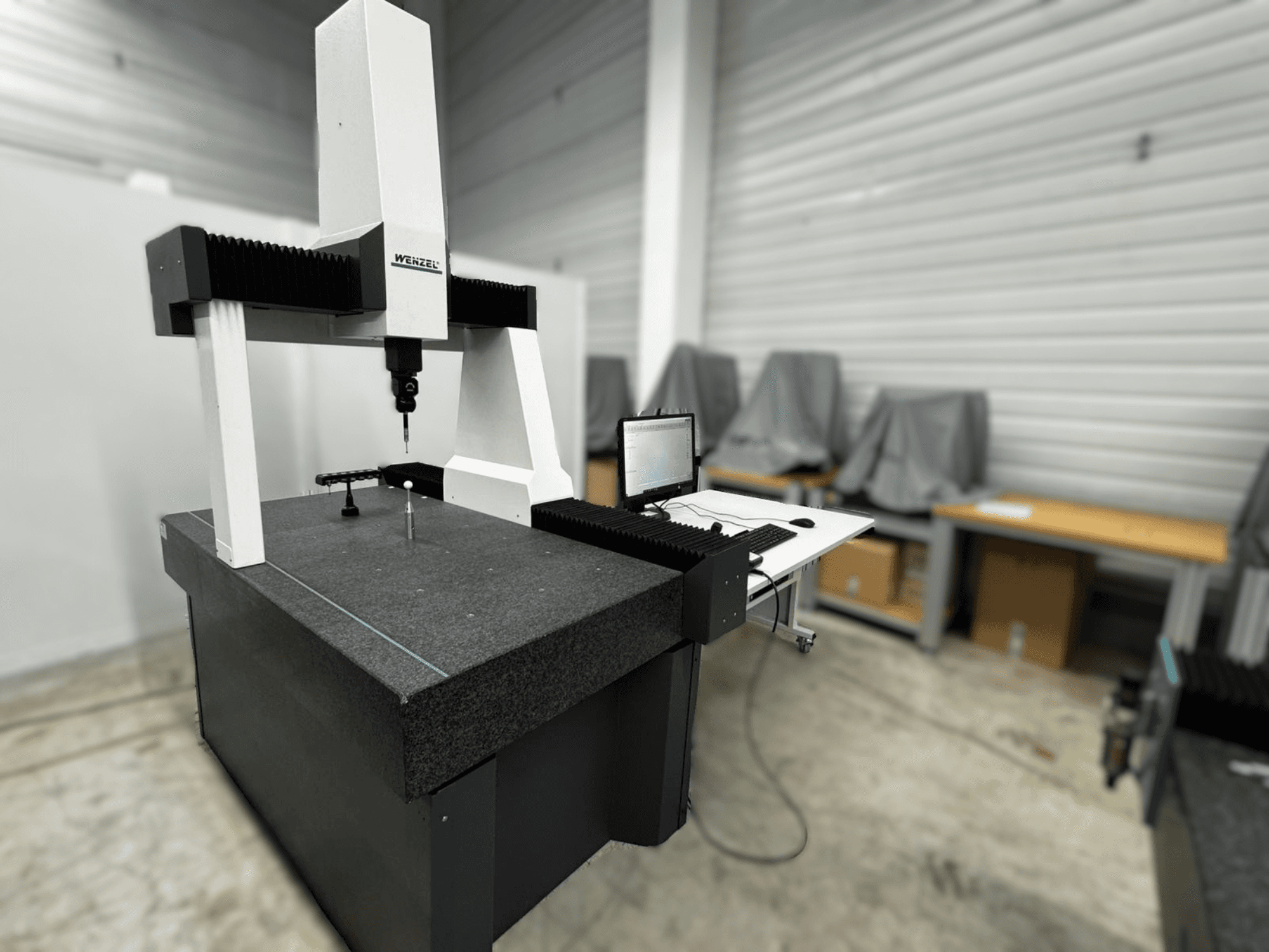 Координатно-вимірювальна машина Wenzel LH 54 у вигляді збоку, з датчиком і комп'ютерним інтерфейсом на сірій основі.