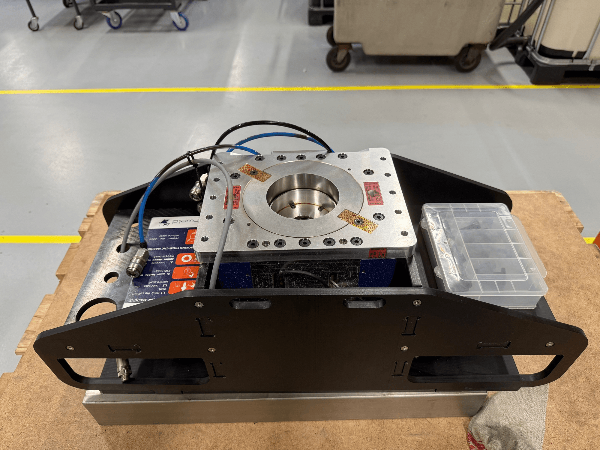 Оброблений металевий компонент з синіми кабелями, футляром для аксесуарів і пласкою основою, показаний зверху, ідеально підходить для механічних застосувань.