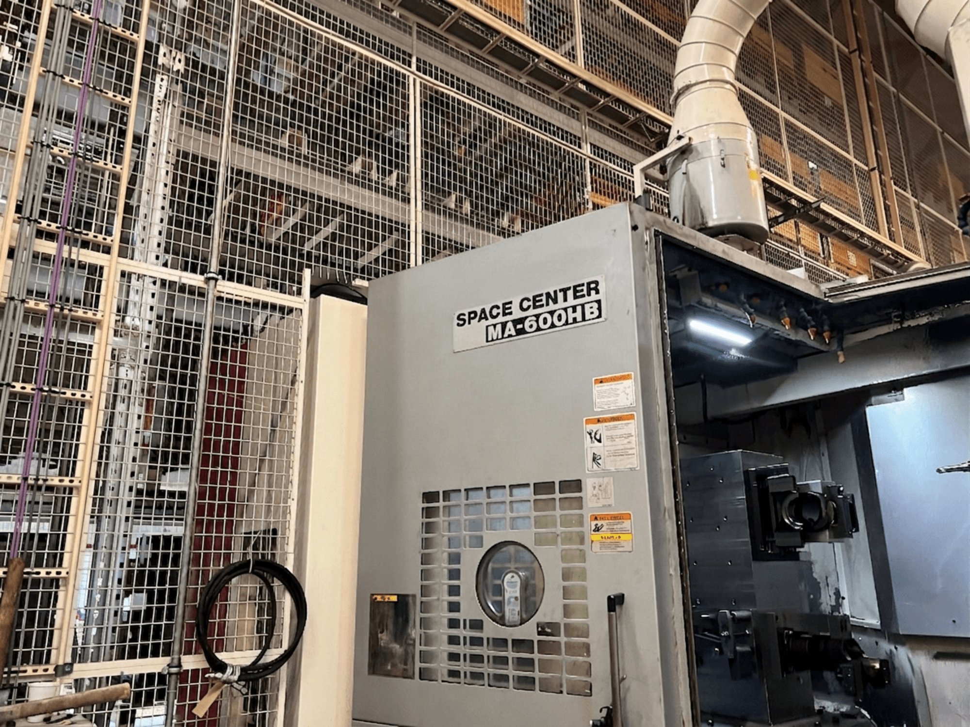 Горизонтальний обробний центр Okuma MA-600HB, вид спереду, з робочою панеллю та форсунками для подачі охолоджувальної рідини.