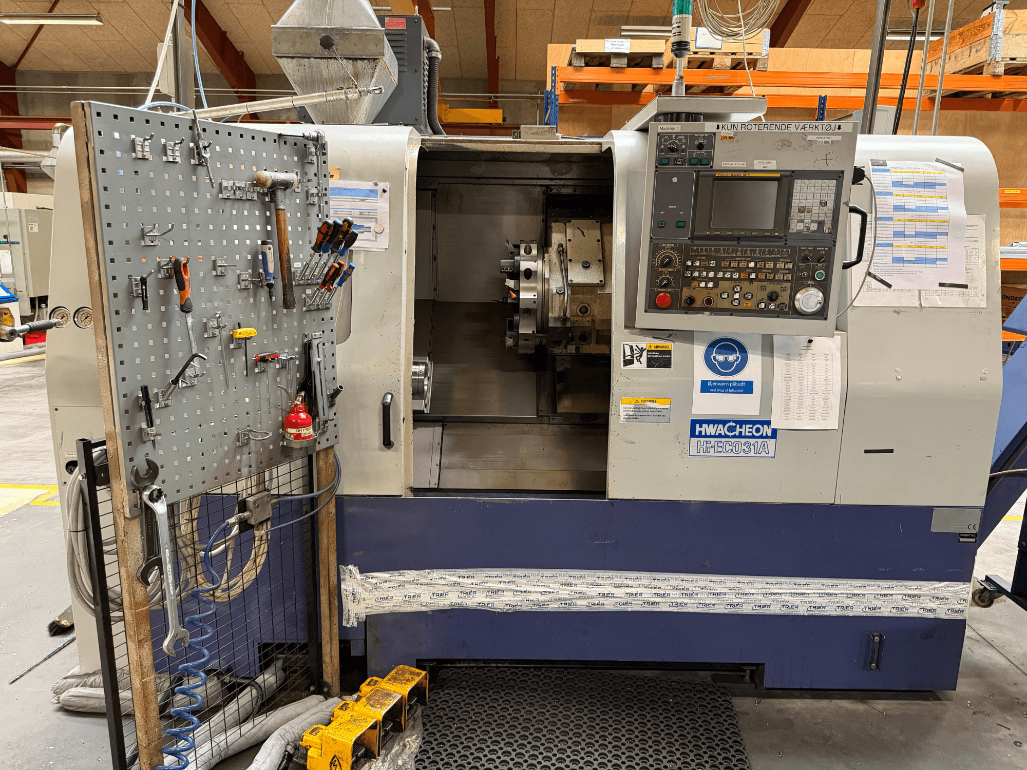 Горизонтальний токарний верстат HWACHEON HiEco-31A з панеллю керування, інструментами, розміщеними збоку, та хорошою оглядовістю внутрішньої частини верстата.
