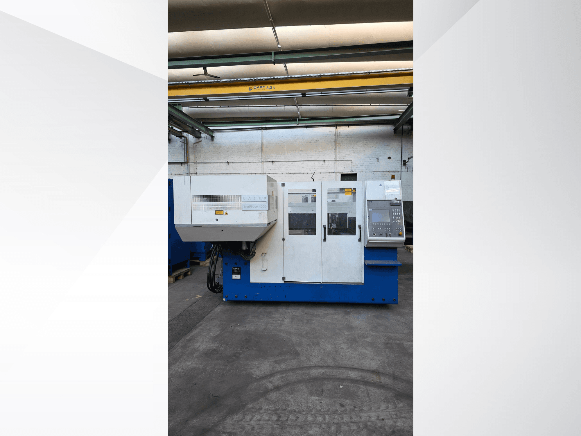 Лазерний різак TRUMPF TruLaser 3030 CO2, вигляд спереду, панель керування та попередження про безпеку на зовнішній стороні.