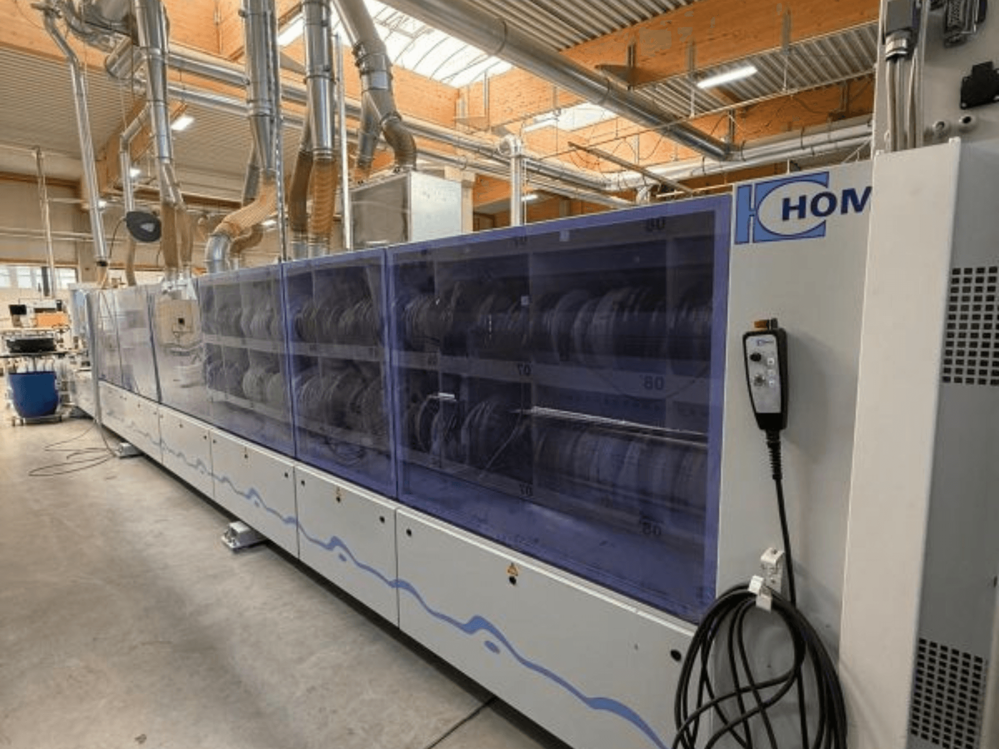 Промислова пральна машина HOM, вид спереду, з прозорою панеллю для відображення посуду; панель управління з кнопками збоку.