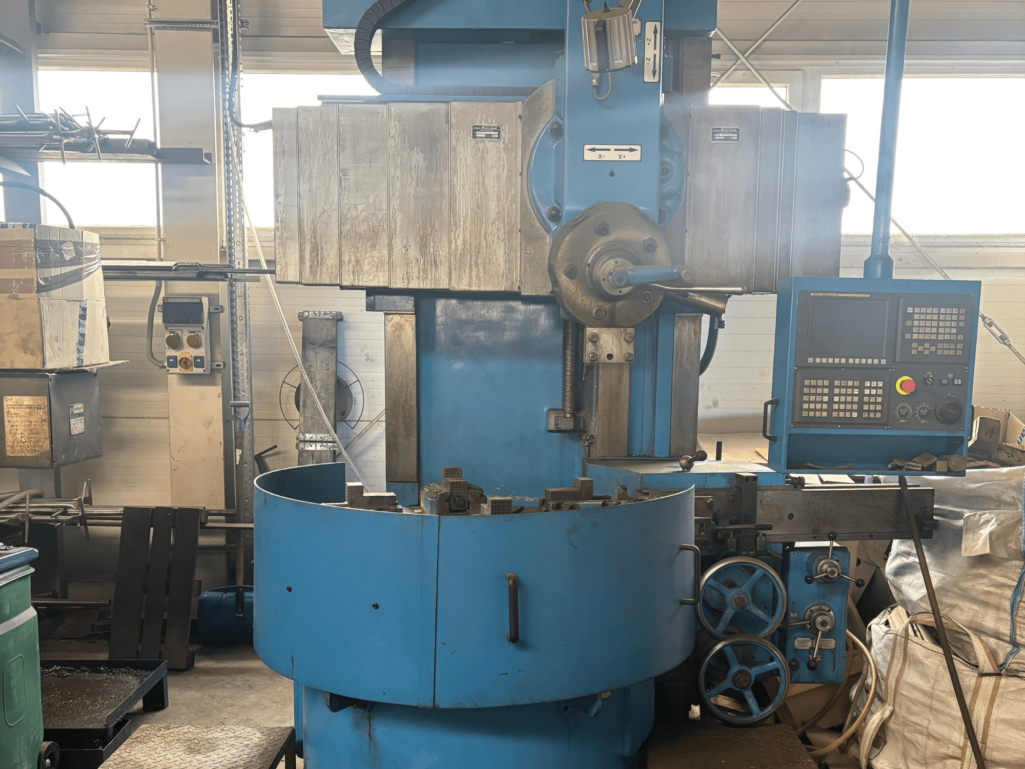 Промисловий фрезерний верстат невідомого бренду, вид спереду, з синім корпусом і цифровою панеллю керування.