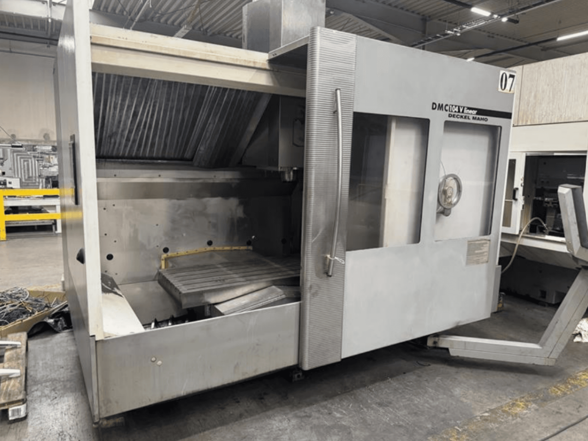 Лінійний верстат DMC 104 V від Deckel Maho, вид спереду, з порожньою зоною обробки з великим робочим столом.