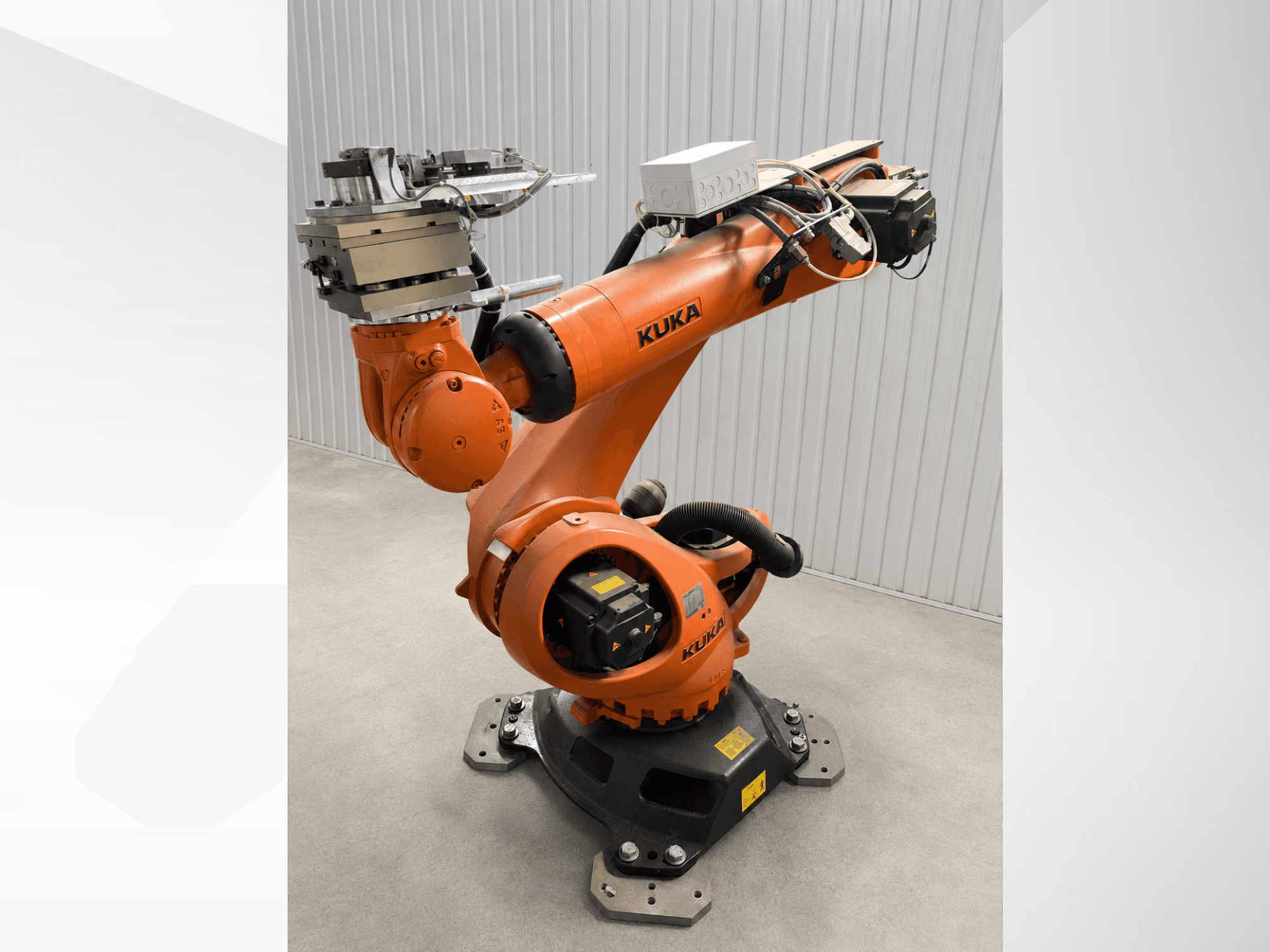 Додатковий маніпулятор робота KUKA KR 90 R3100 оранжевого кольору, вид збоку, на якому видно шарніри, контролер та кріплення інструменту на кінцевому ефекторі.