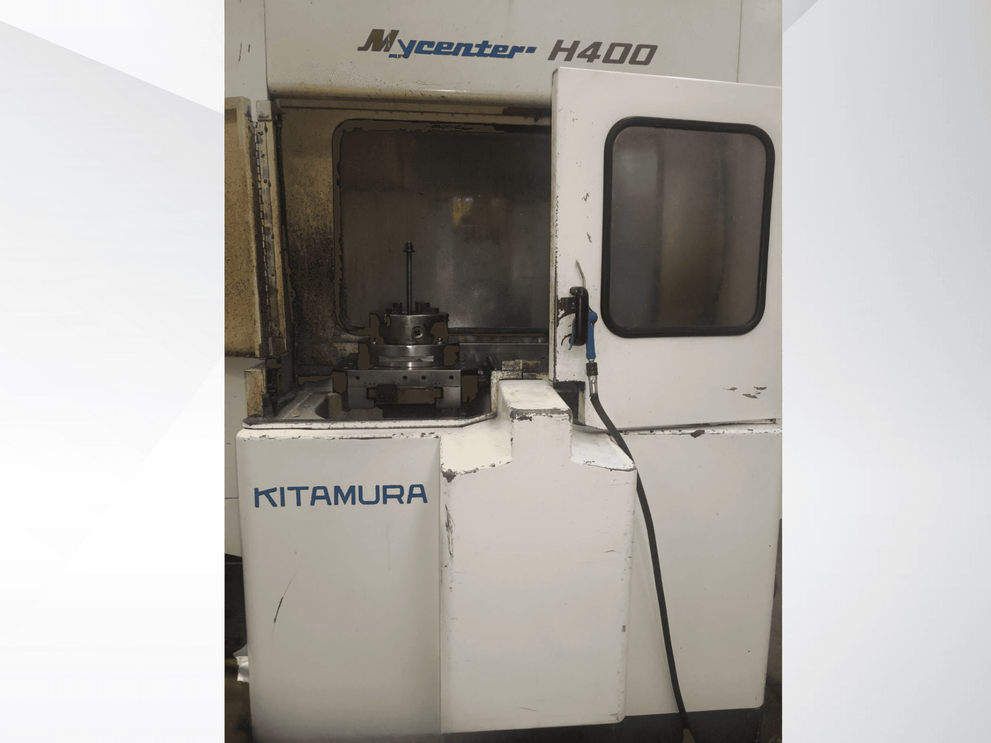 Верстат з ЧПУ Kitamura Mycenter H400, вид спереду, з видимою робочою зоною і панеллю керування, зі слідами використання.