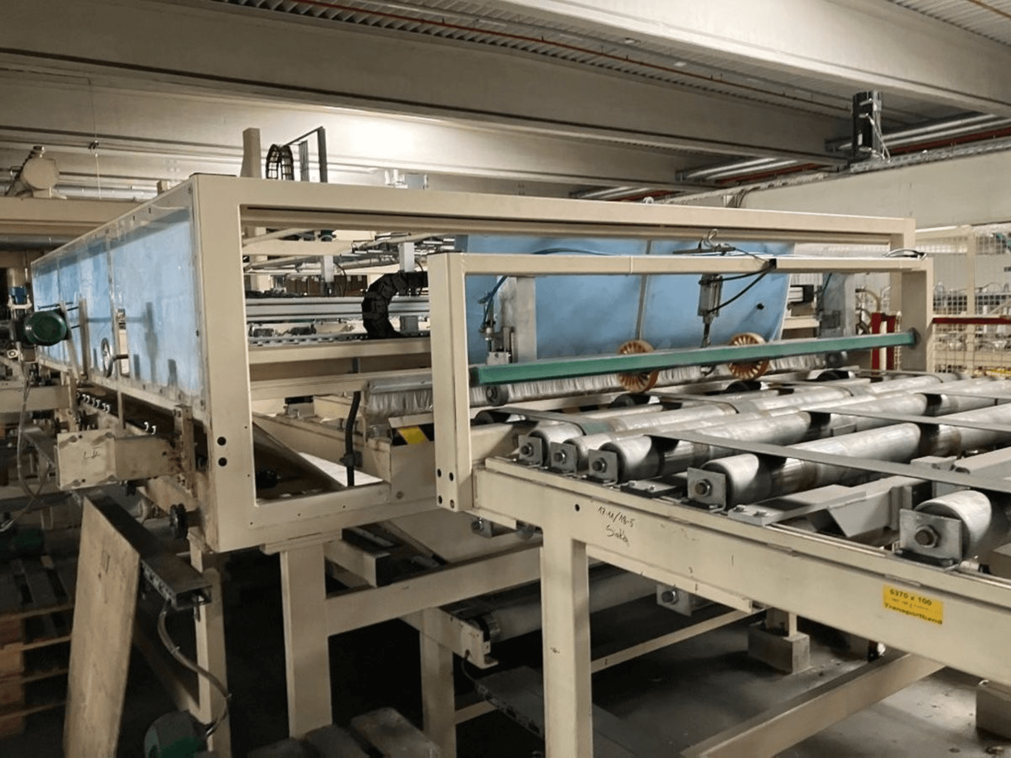 Ламінаційний прес WEMHÖNER KT-F-1E, вид збоку, з роликами та елементами керування для обробки матеріалу в заводських умовах.