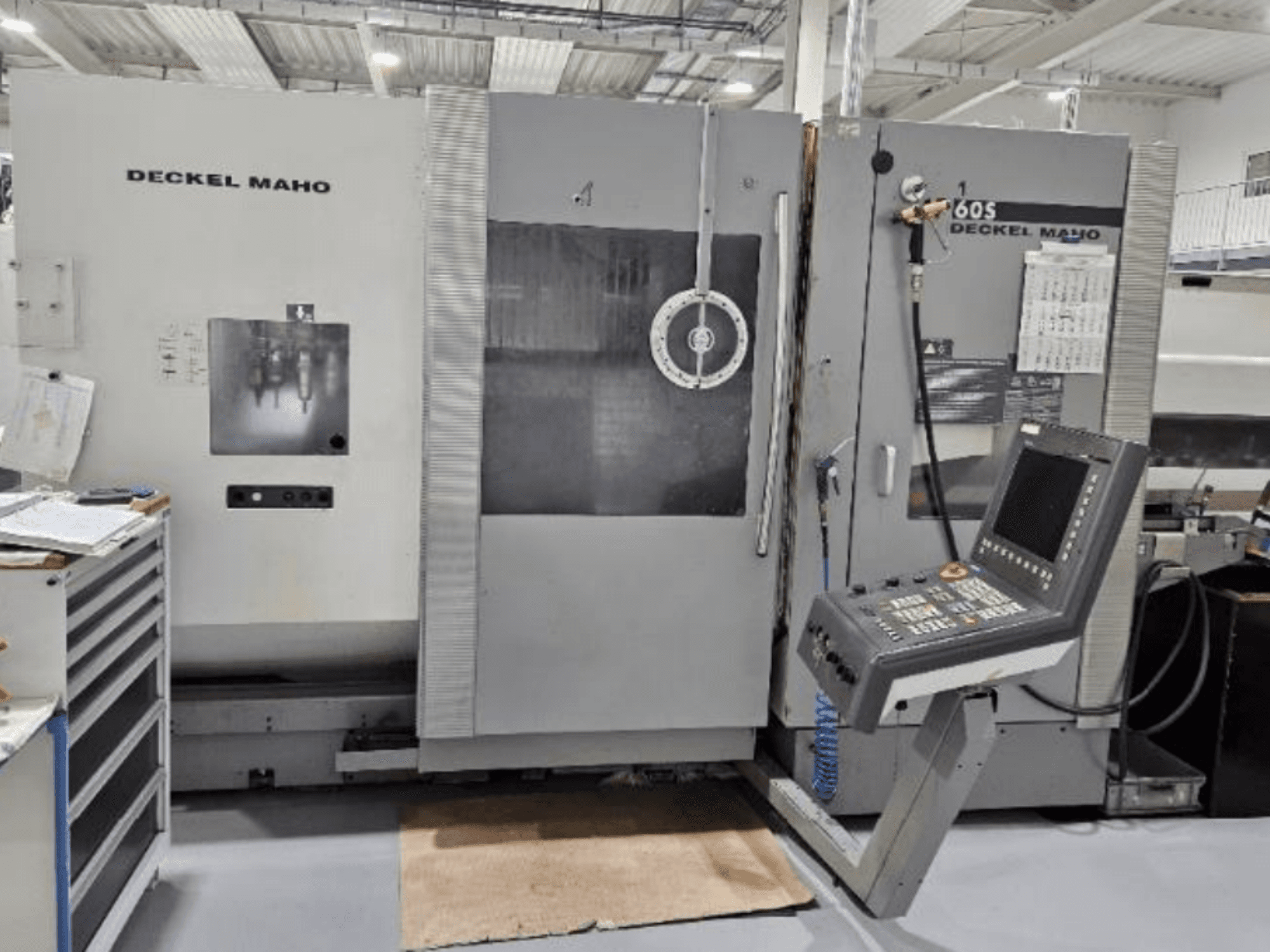 Вид спереду верстата з ЧПК DECKEL MAHO 60S з панеллю керування, видно інструменти, в умовах майстерні.