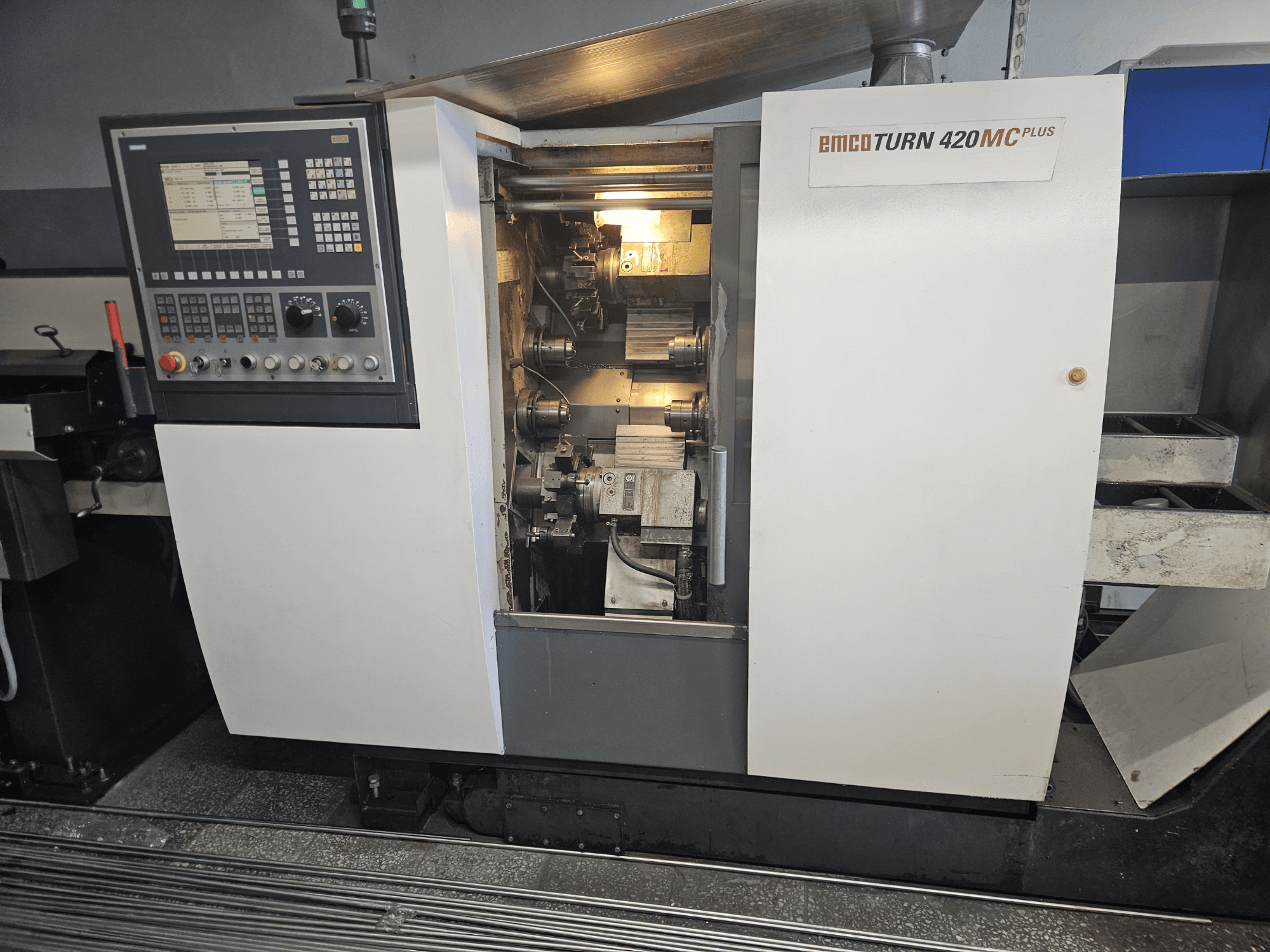 Багатошпиндельний верстат EMCO TURN 420 MC Plus, вид спереду з панеллю керування та внутрішніми компонентами.