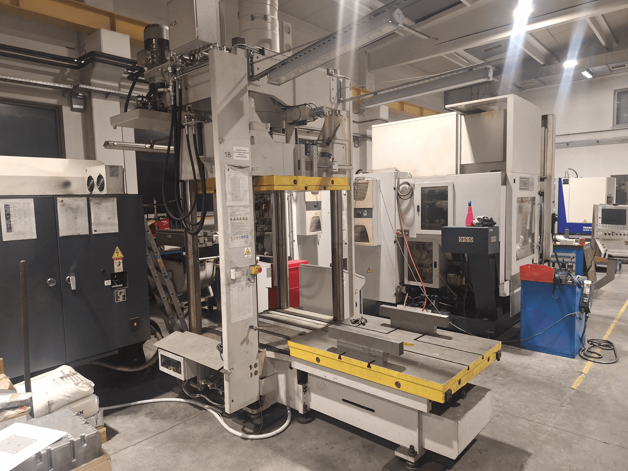 Горизонтальний фрезерний верстат Synergic, вид спереду; оснащений широким столом і різними панелями керування, в умовах майстерні.