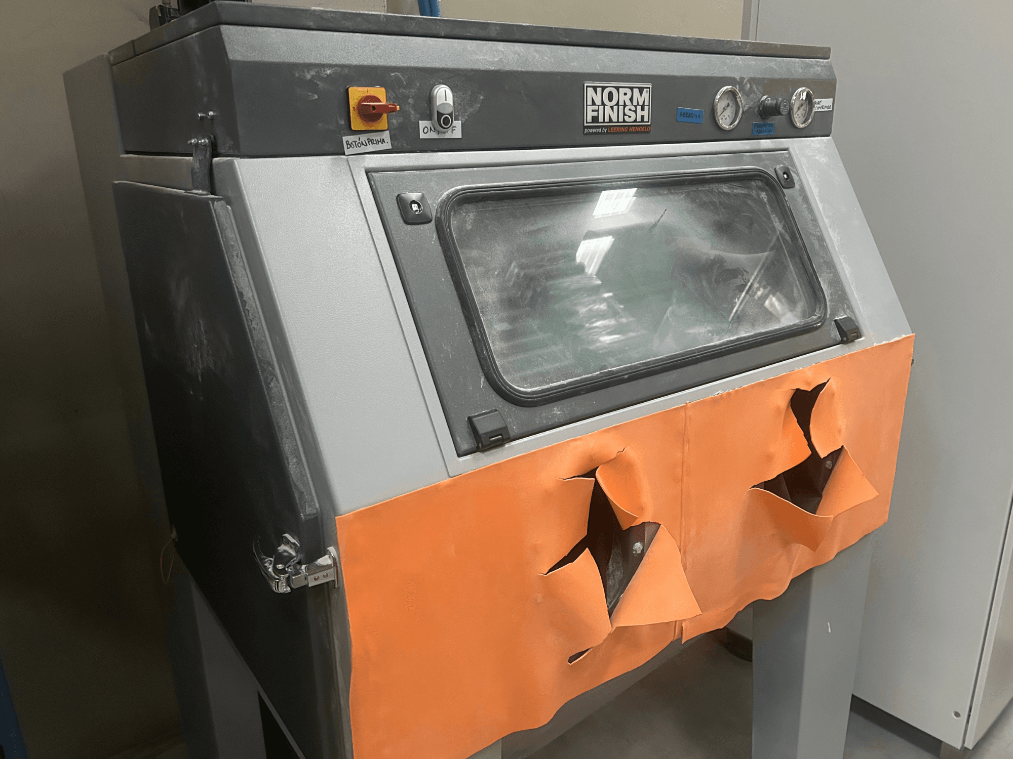 Пластиковий 3D-принтер EOS P 396 сірого кольору, вигляд збоку зі зношеною помаранчевою кришкою та видимою панеллю керування, запилений.