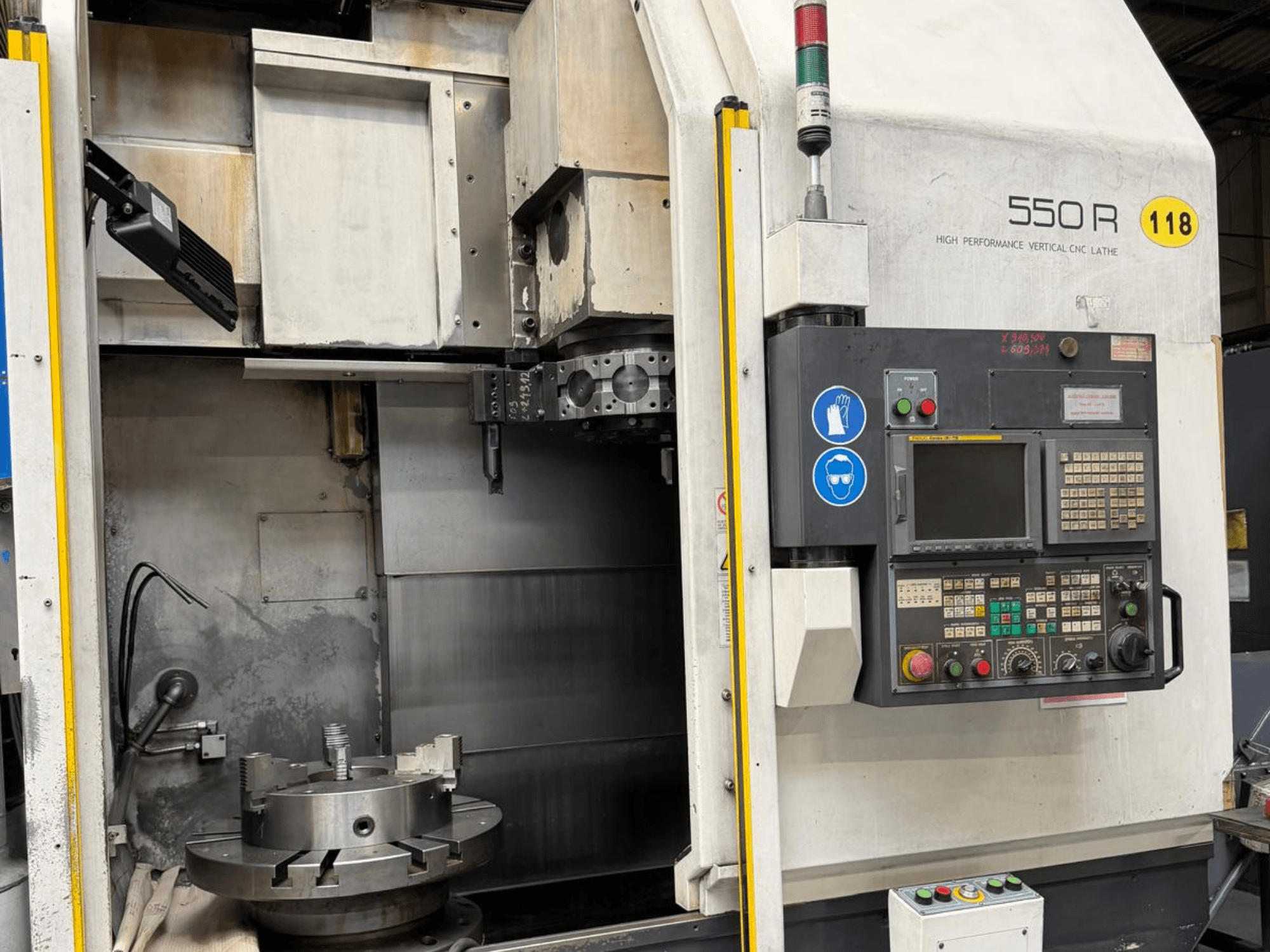 Високопродуктивний вертикальний токарний верстат з ЧПК 550 R, вид спереду, з панеллю керування, обертовим патроном та робочими компонентами.