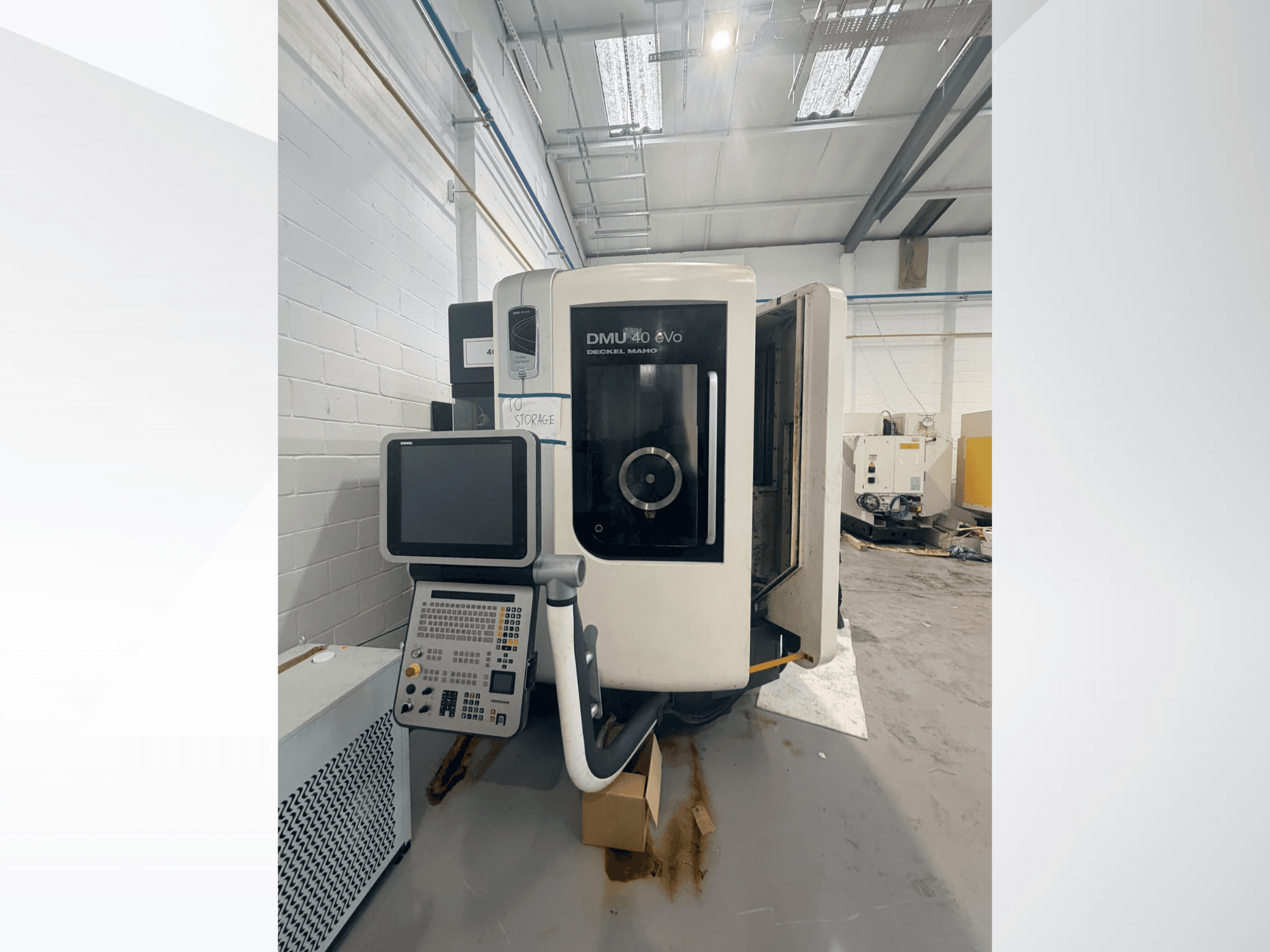 Вертикальний обробний центр DMG DMU 40 evo у фронтальному ракурсі: на фото зображено панель управління та зону шпинделя, а на задньому плані — робоча зона.