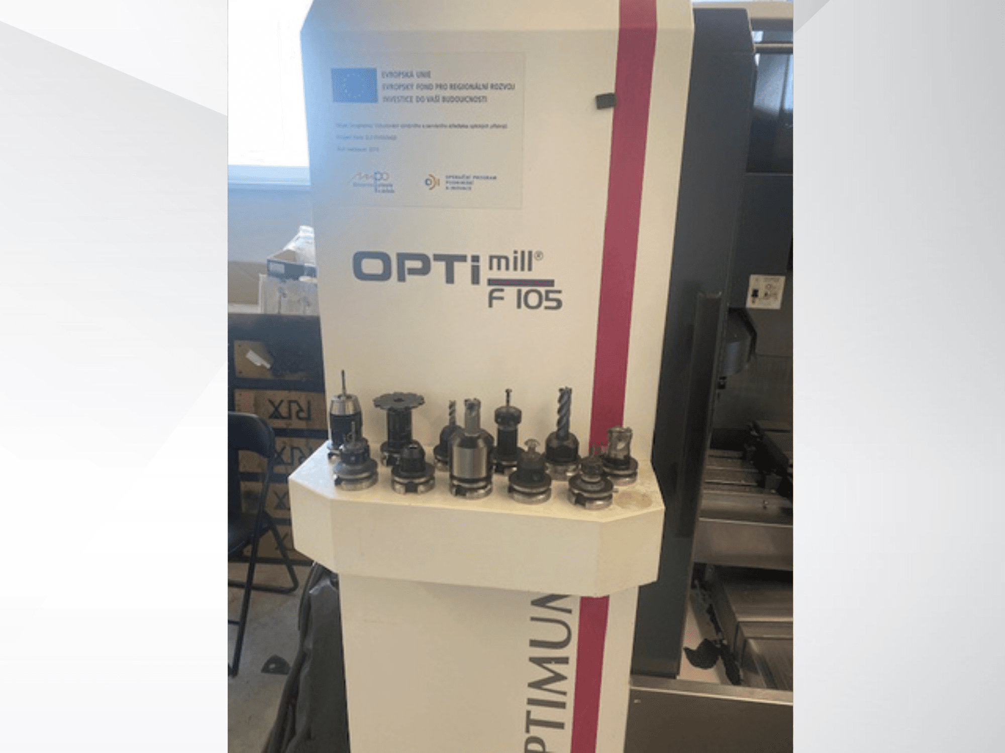Вигляд спереду вертикального обробного центру Optimum Optimill F105 з різними насадками, розміщеними збоку.