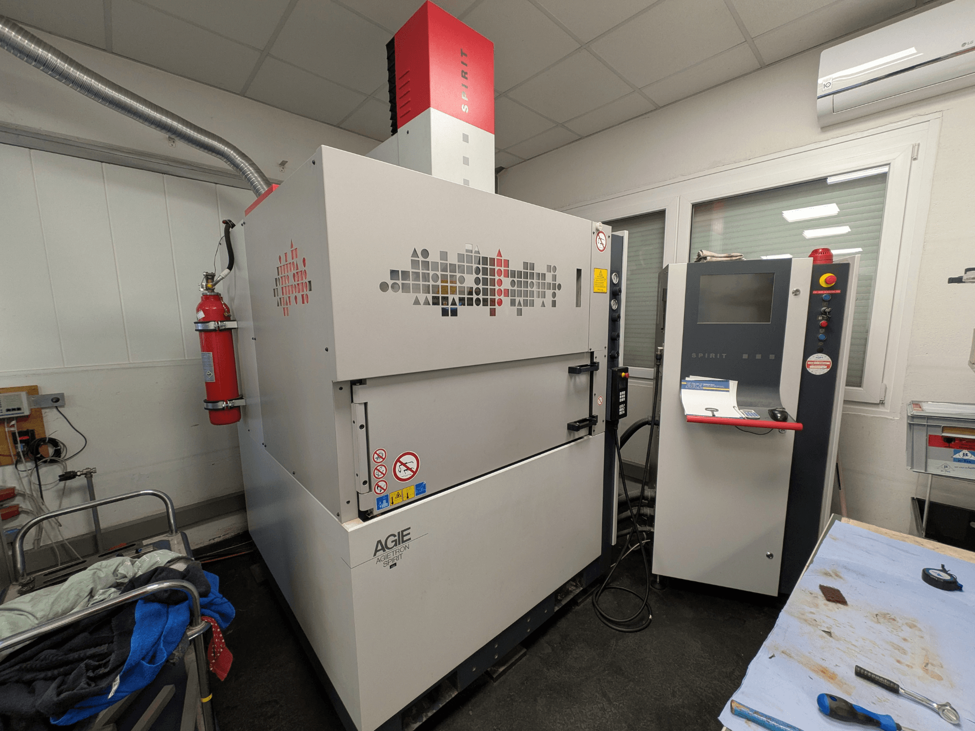 Висікальний електроерозійний верстат AGIE AGIETRON SPIRIT 3, вид збоку, демонстрація панелі керування та вогнегасника.