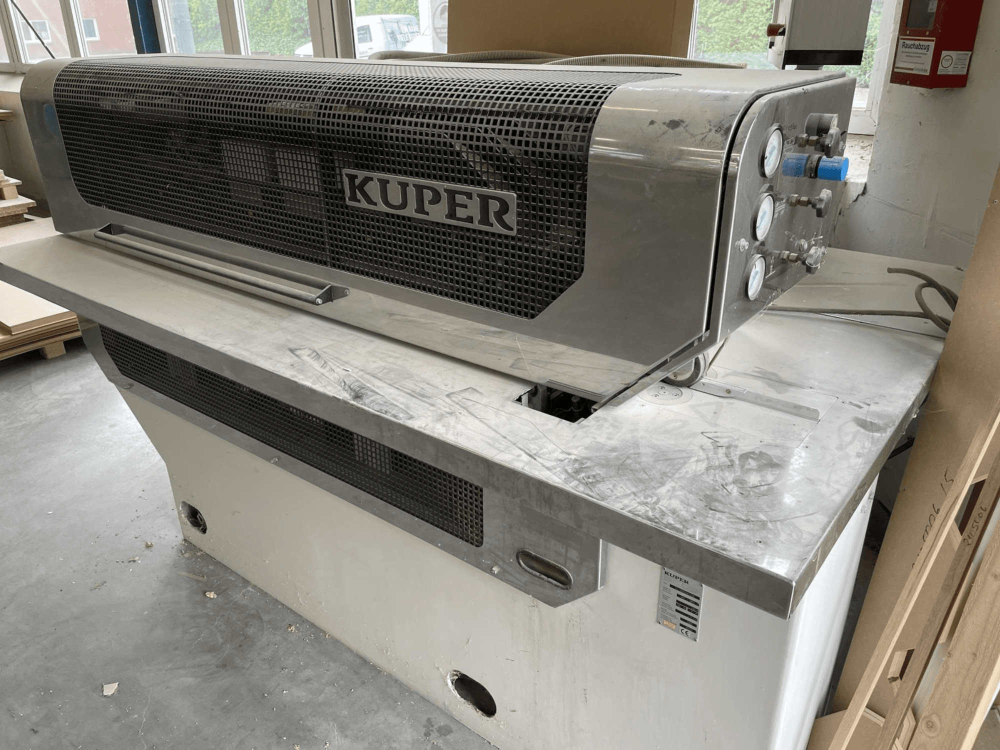 Гільйотина для шпону KUPER FLI, вид спереду, з корпусом з нержавіючої сталі, вимірювальними приладами та зоною чистого різання на робочому столі.