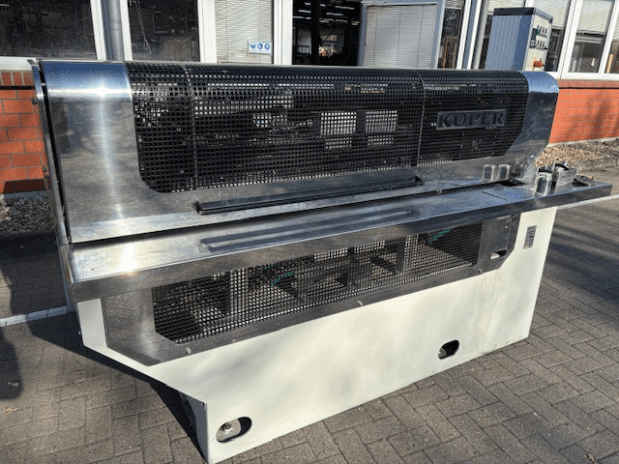 Гільйотина для шпону KUPER FLI, вид спереду, з корпусом з нержавіючої сталі та захисною сіткою для безпечної роботи.