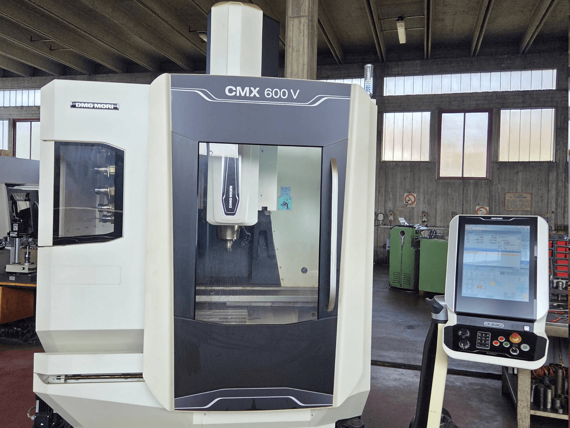 Вертикальний обробний центр DMG MORI CMX 600V у фронтальному ракурсі, на якому видно панель управління та деталі зони шпинделя.