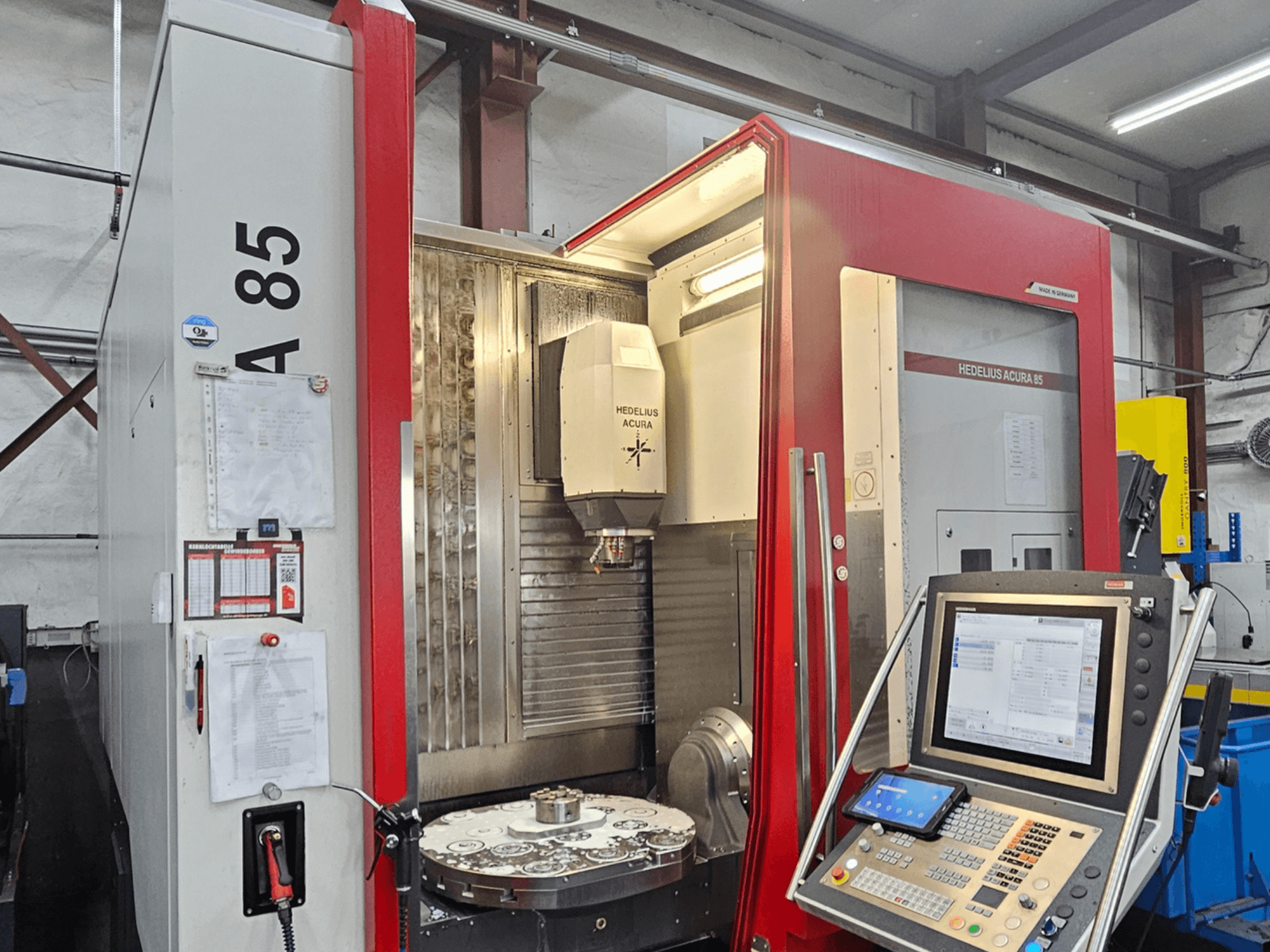 Вертикальний обробний центр HEDLIUS Acura 85, вид спереду, оснащений панеллю керування та обертовим столом для точної обробки.