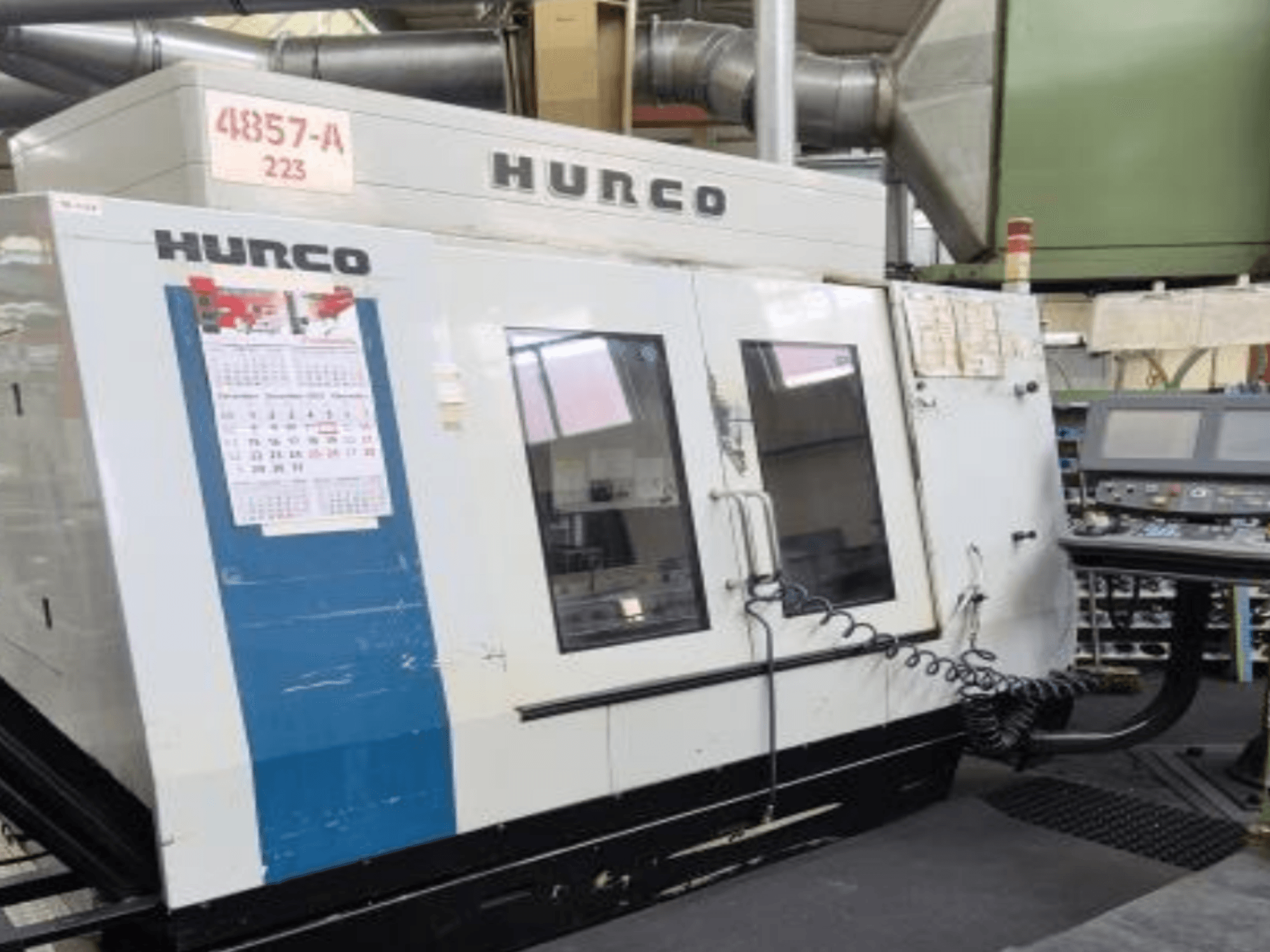 Вертикальний обробний центр Hurco VMX 42 спереду, з панеллю керування, календарем і металевими зовнішніми деталями.