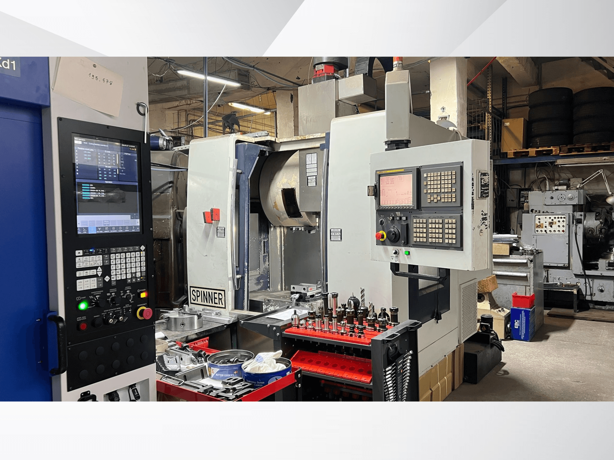 Верстат з ЧПК з панеллю керування, інструментами та заготовками, видимими спереду в умовах майстерні.