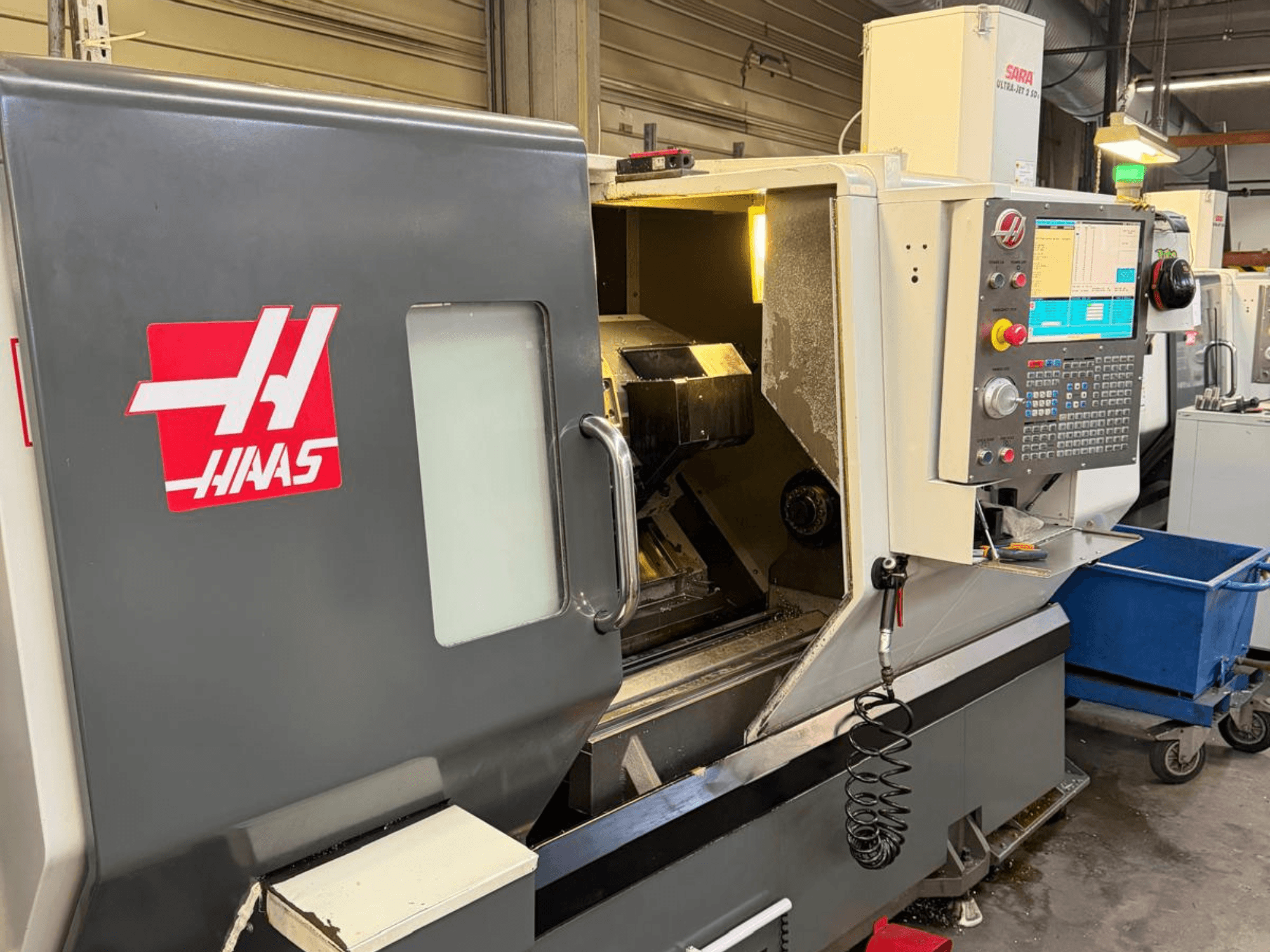 Горизонтальний токарний верстат HAAS DS-30SSY, вид спереду, з панеллю керування та внутрішніми компонентами, в умовах майстерні.