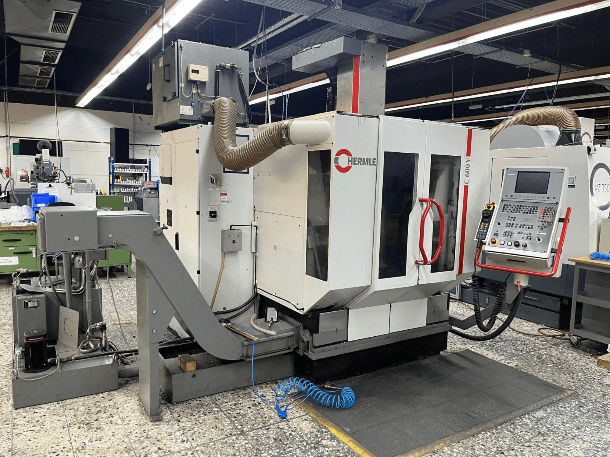 Вертикальний обробний центр HERMLE C 600 V в майстерні, вид спереду з панеллю керування та вентиляцією.