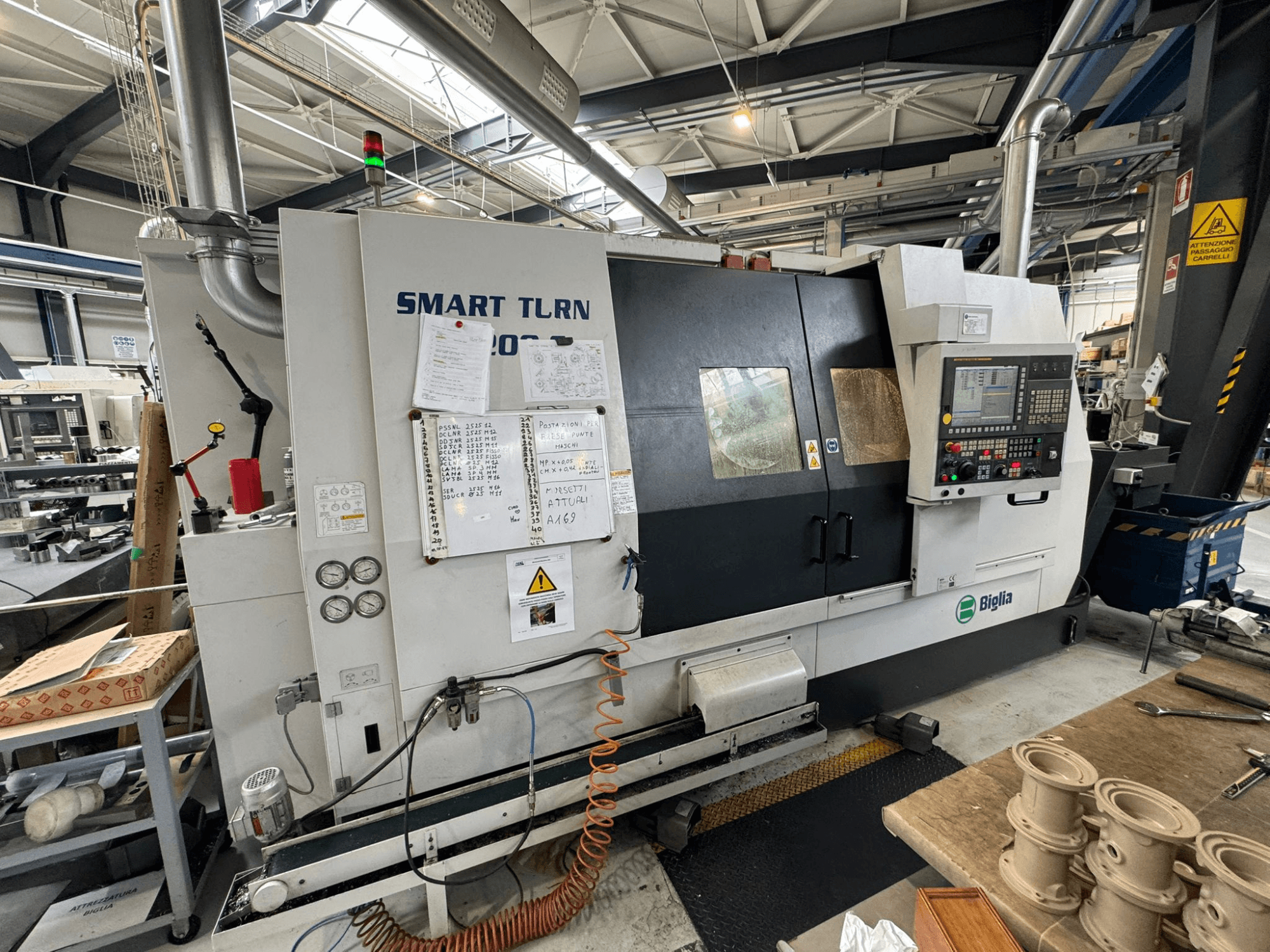 Токарно-фрезерний центр Biglia Smart Turn B1200S в майстерні з панеллю керування, вимірювальними приладами та індикаторами безпеки.